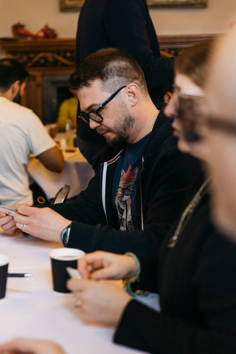 People sitting at a table with some cards.