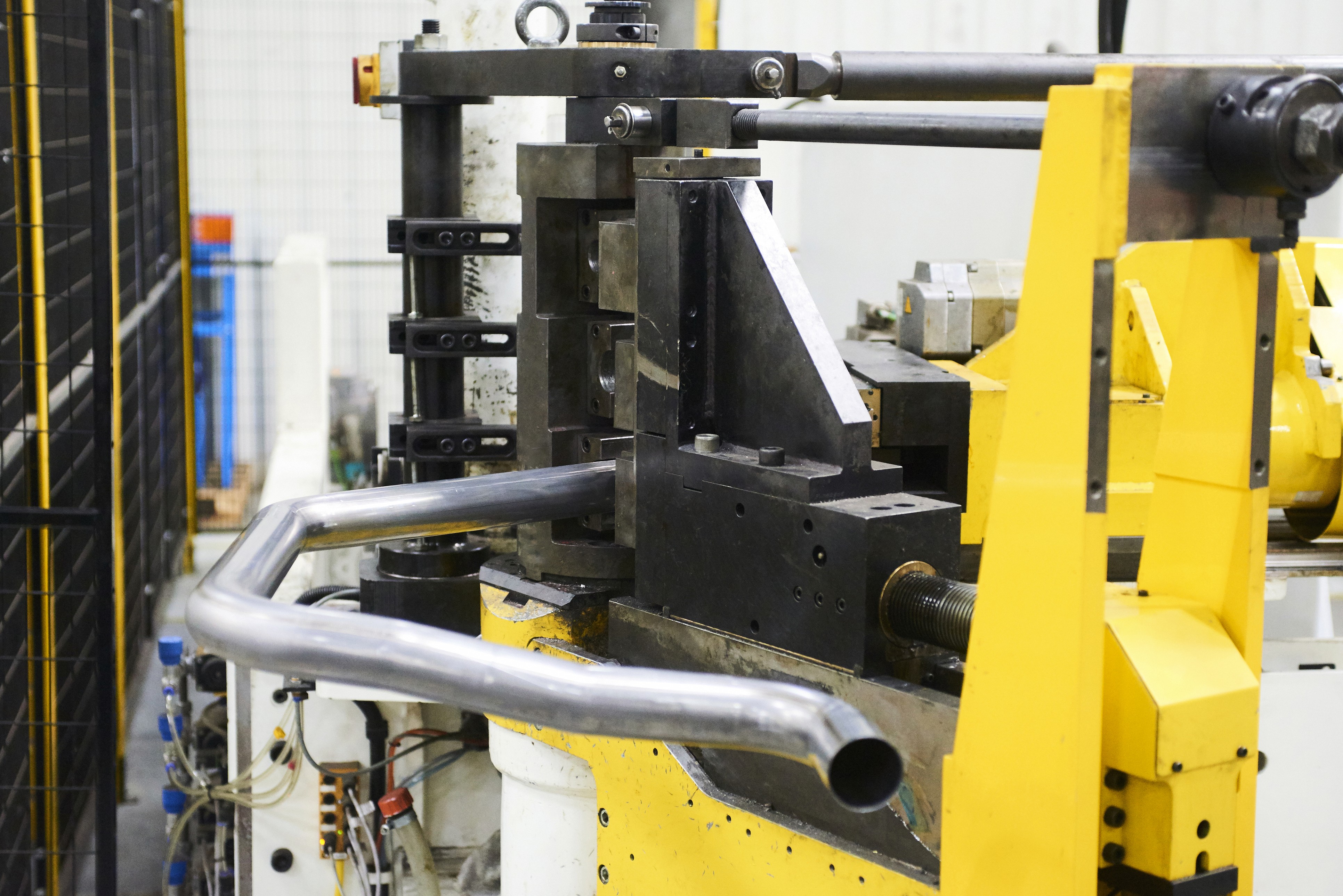 Close-up of a machinery setup with yellow and black components, focusing on pipes and mechanical parts.