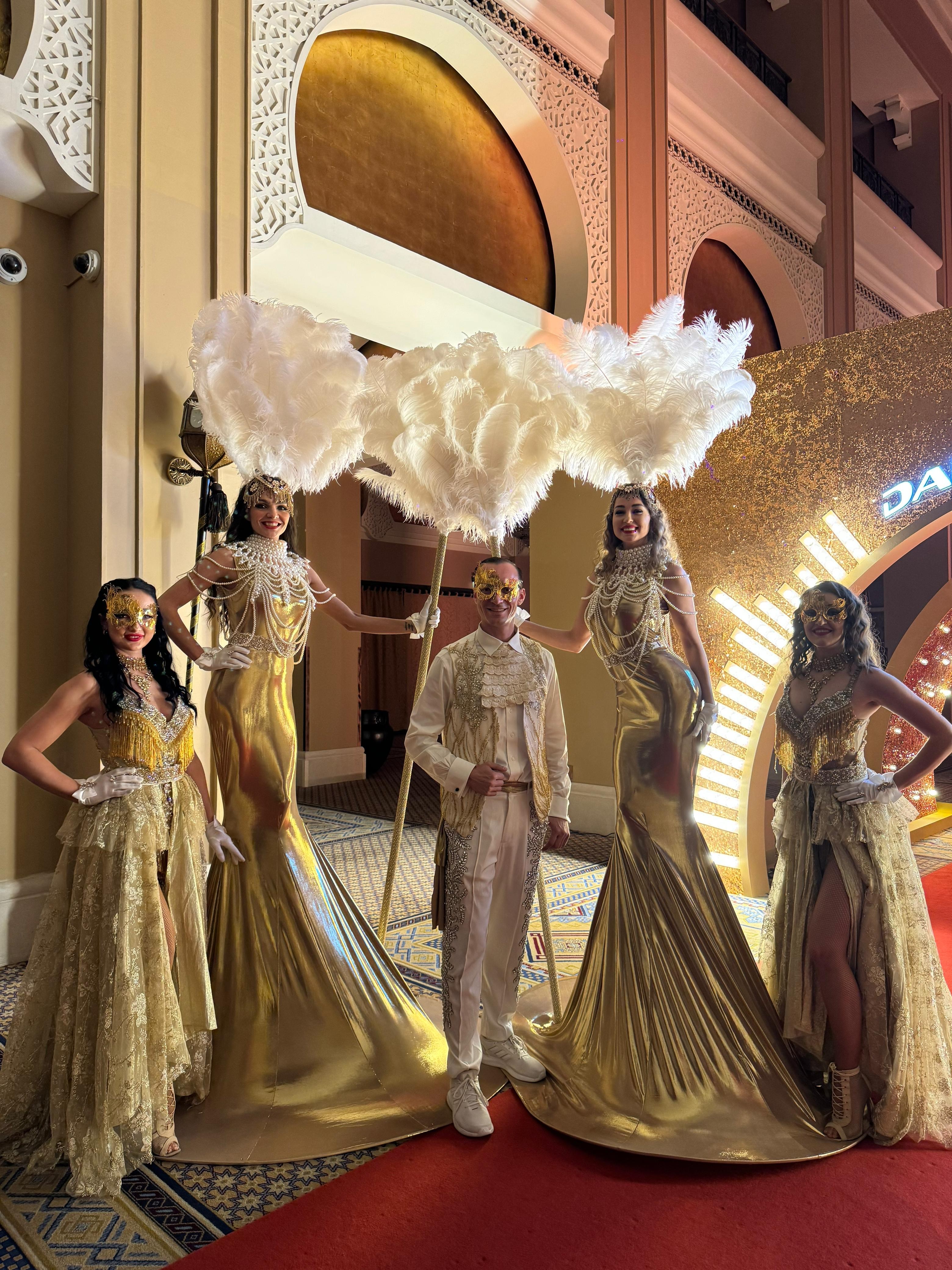 Gold stilt performers with feather props and bespoke costume performers at DAMAC Broker Awards 2024 in Dubai