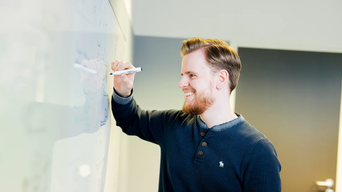 Vriendelijke man die schrijft op een whiteboard over incidenten of klachten management.