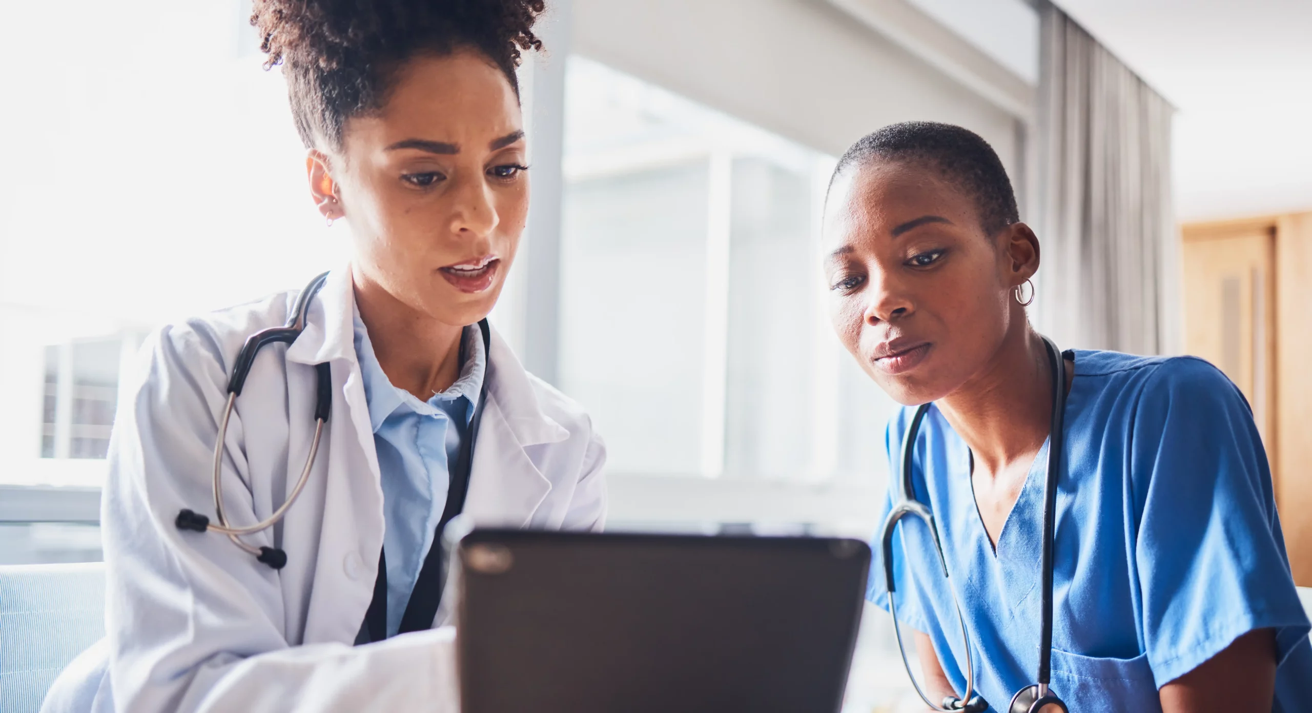 Healthcare workers reviewing a tablet together