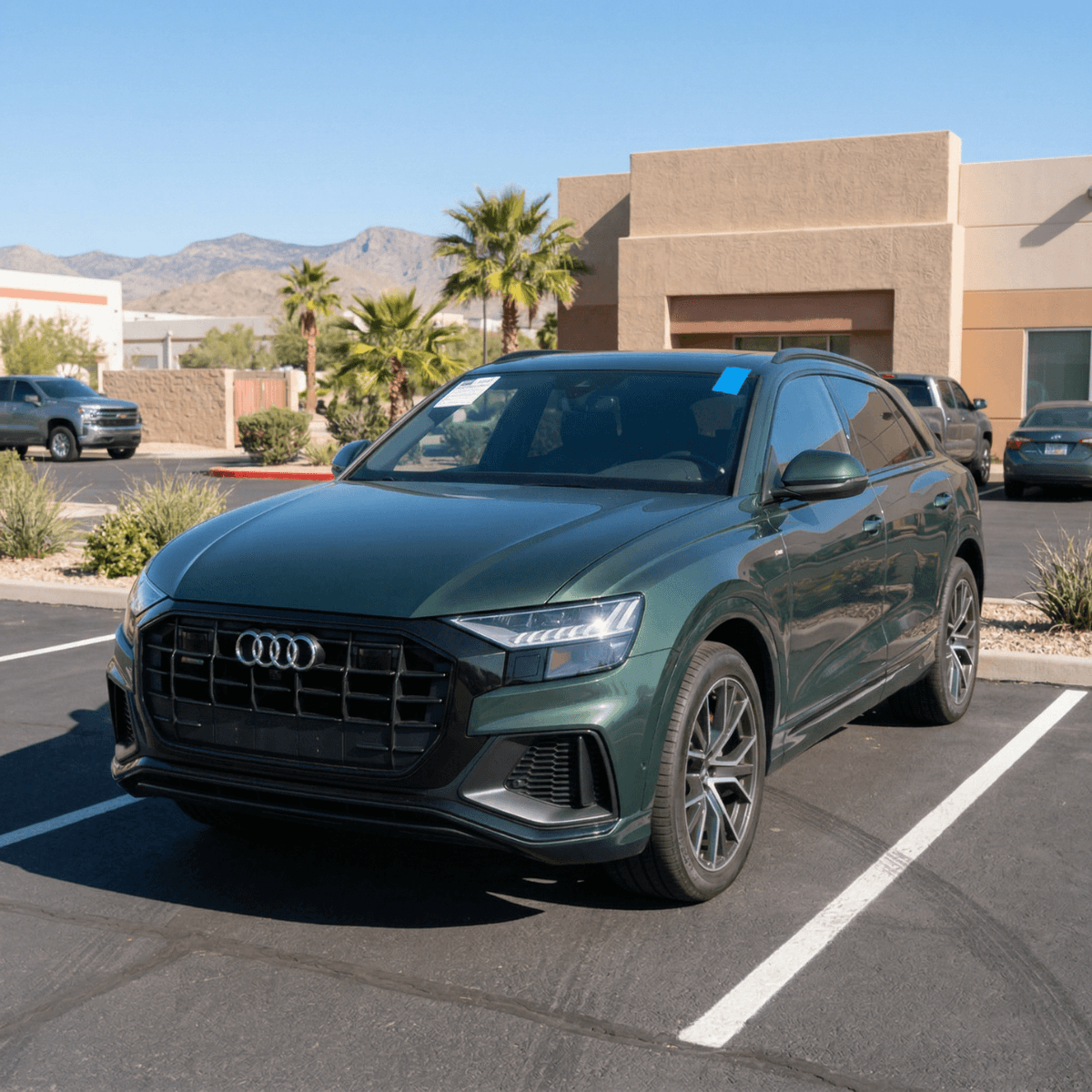 Green Audi Q8 with a sleek new windshield installed at a Nogales commercial parking area