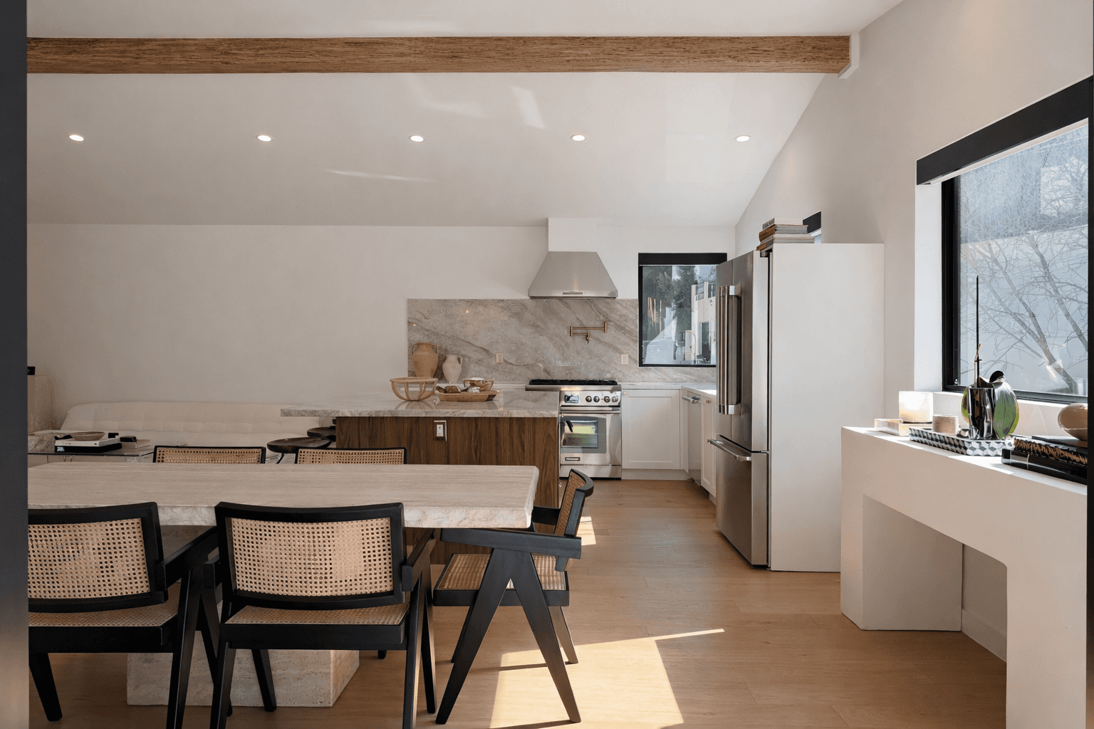 Modern living room with black leather sofas and tree-patterned rug