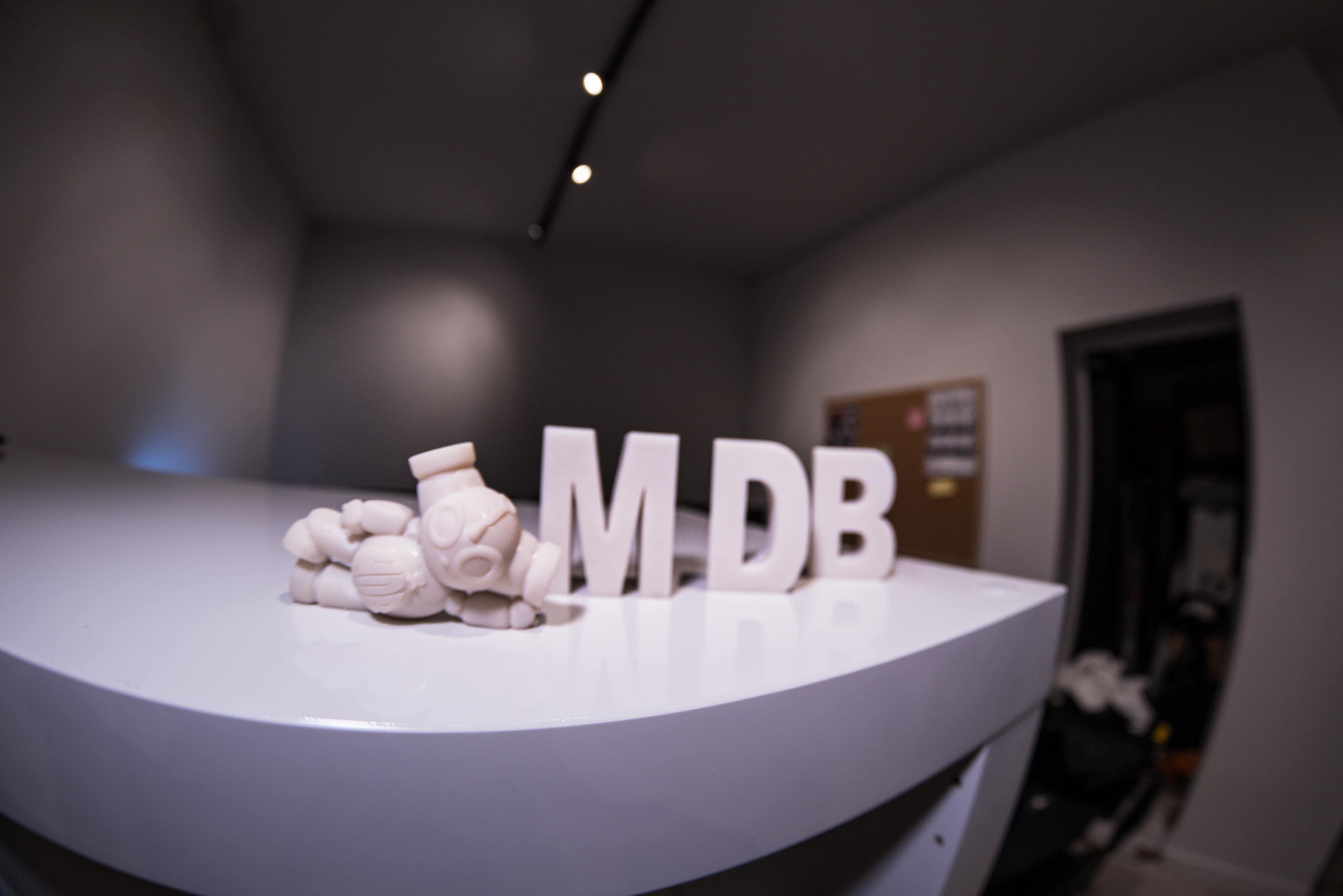 Figurine mascotte avec les trois lettres MDB