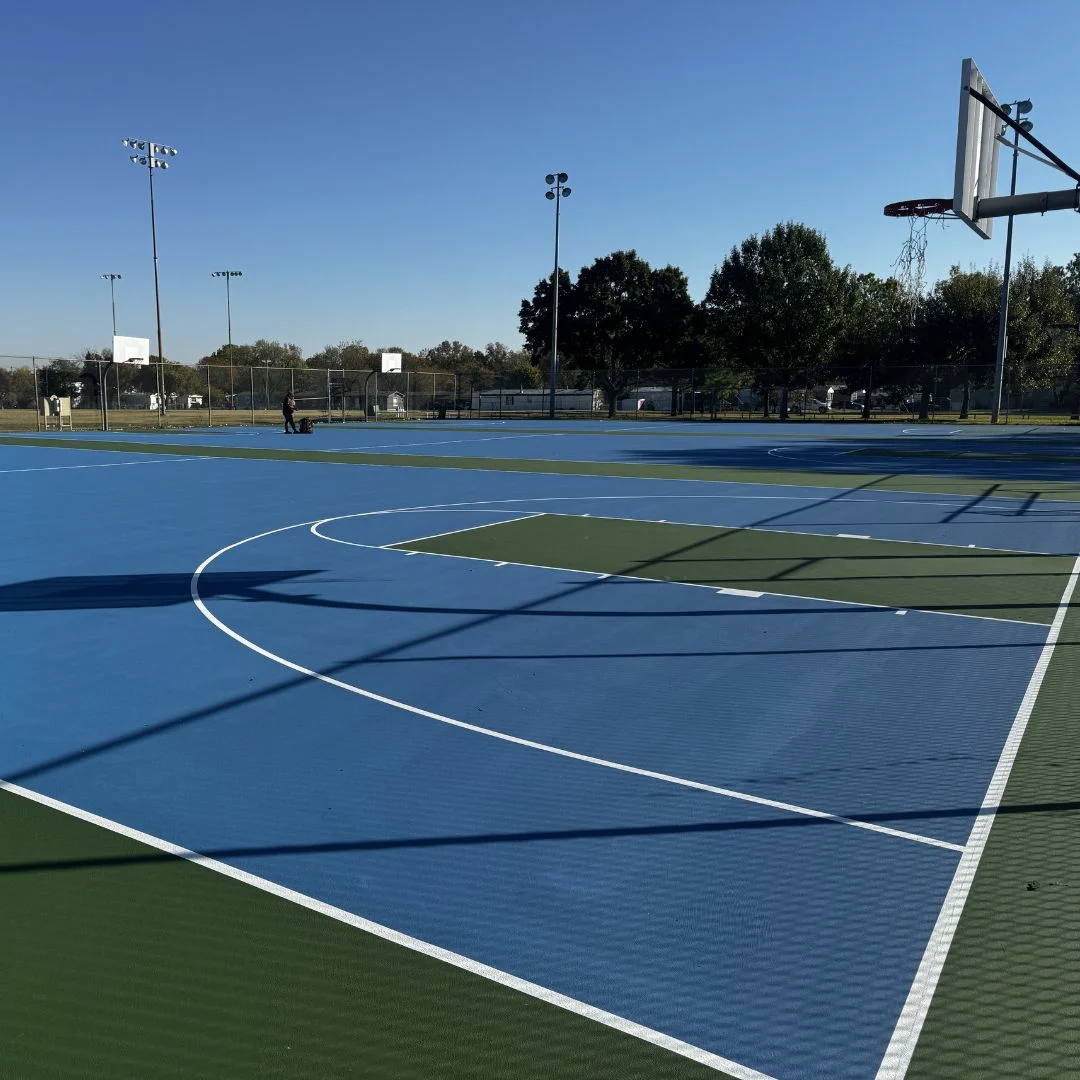 Resurfaced basketball court at Maxwell Park in Tulsa with new blue and green acrylic coating and crisp white striping