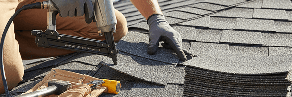 Roofer installing a standing seam metal roof with safety harness