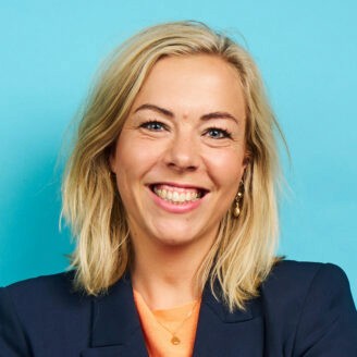 Person smiling and holding a piece of furniture.