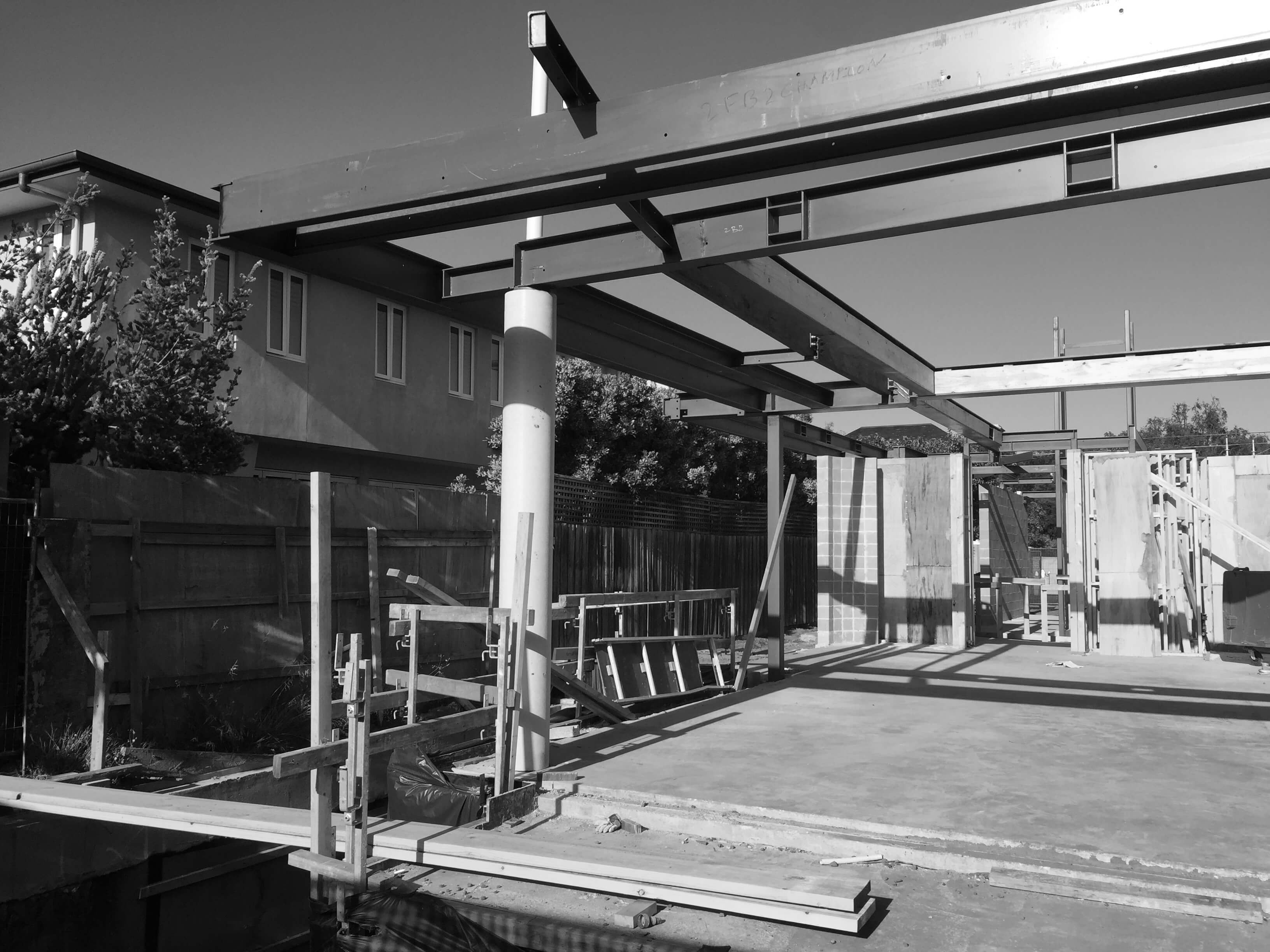 bw_image shows commercial construction project with large concrete columns and structural steel beams with timber framing