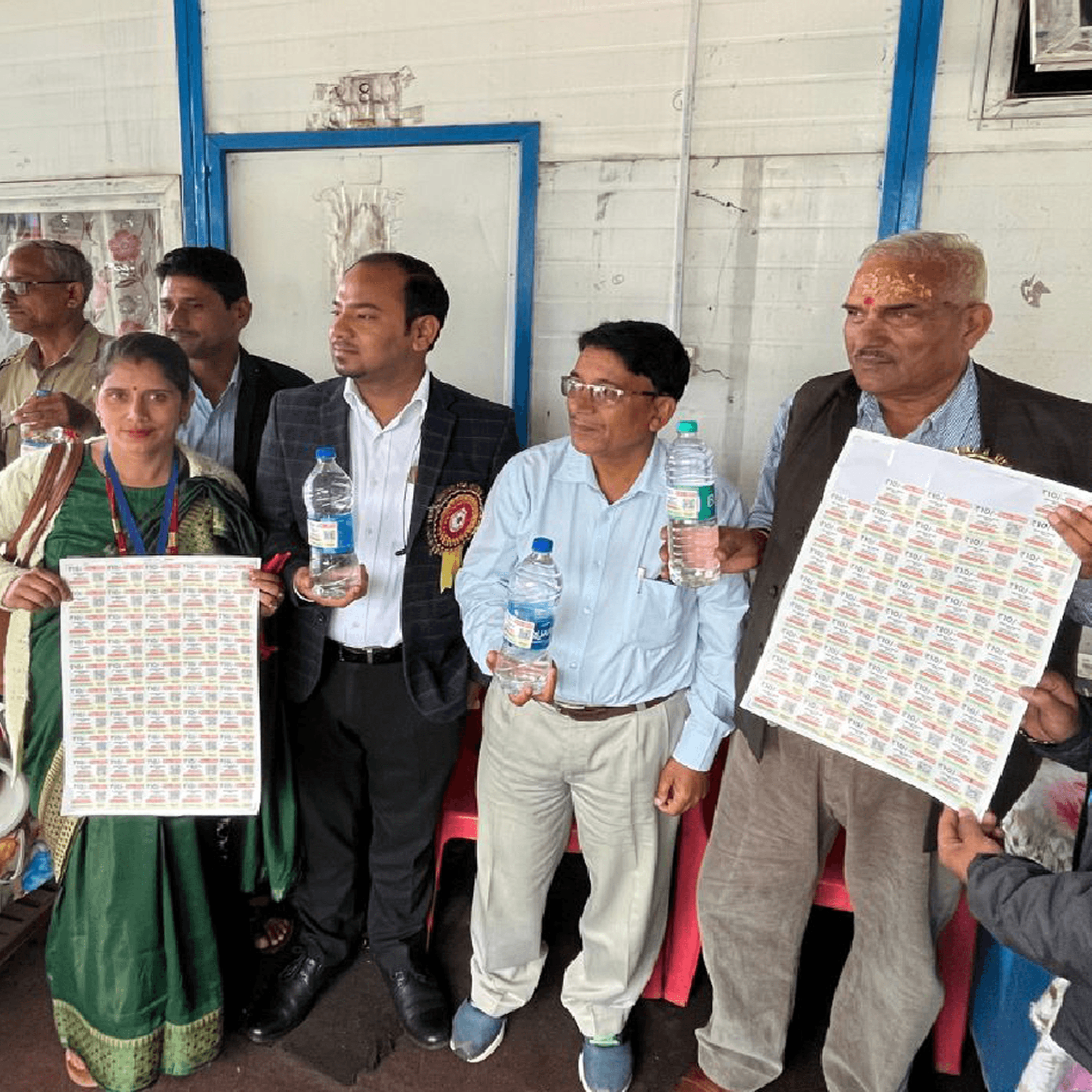 Woman in red outfit poses by a red telephone booth.