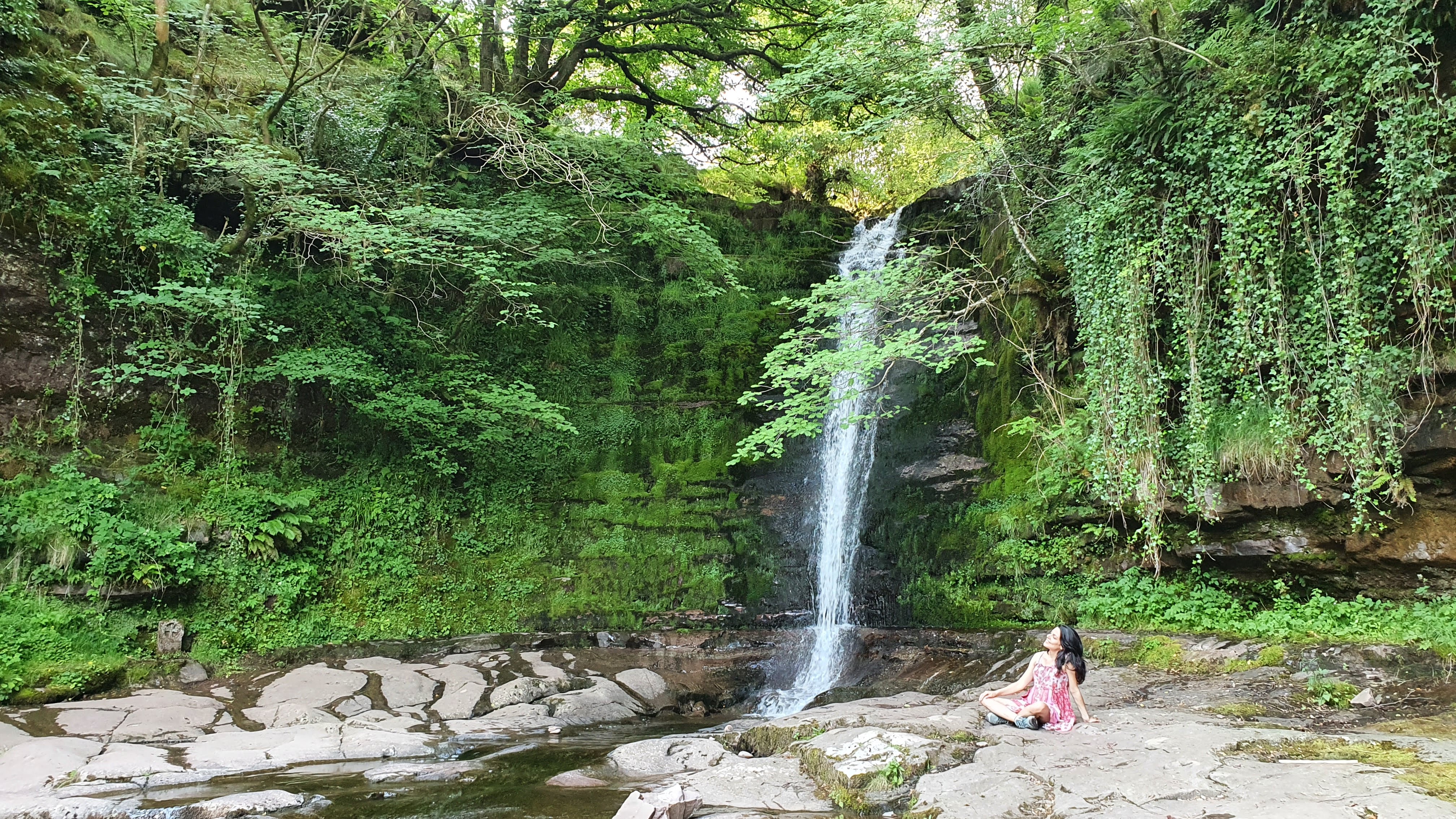 Samira standing at edge of cliff looking at clouds