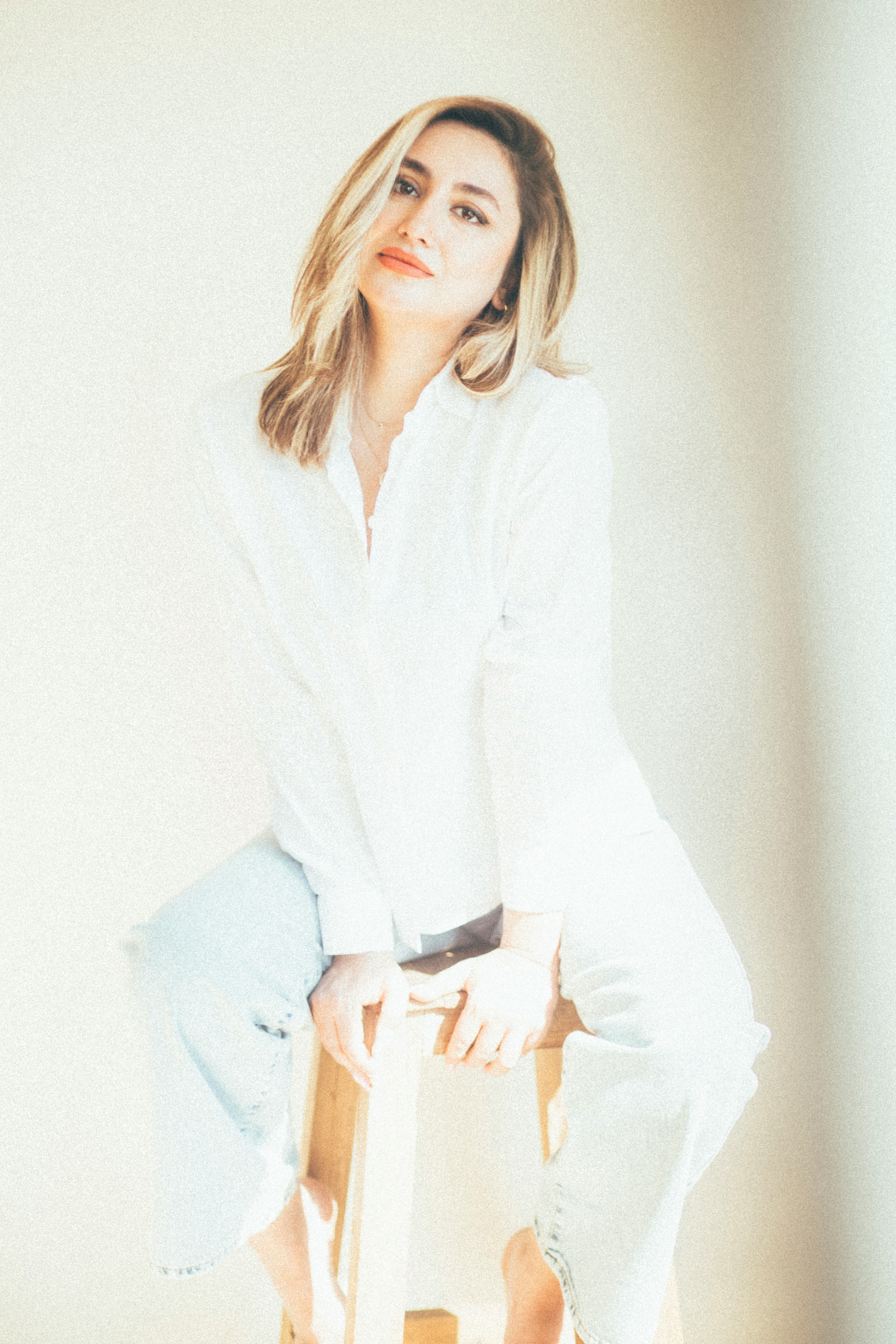 A woman sitting on top of a wooden chair