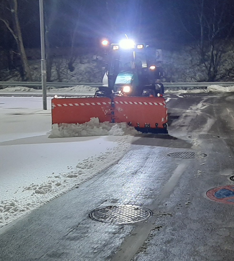 Odśnieżanie traktorem parkingu nocą