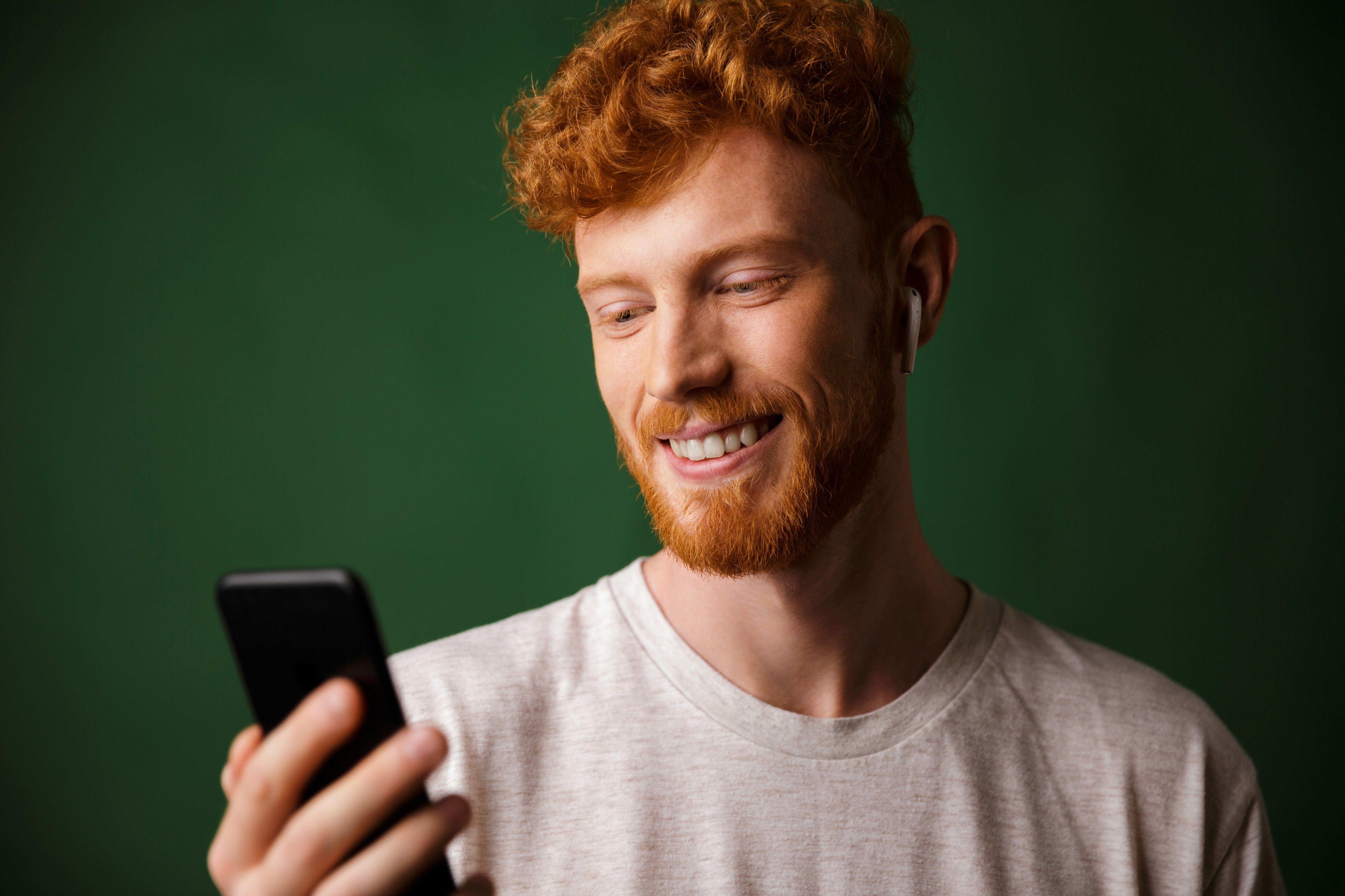Jeune homme regardant un message sur son smartphone, illustration d'un article comparant le RCS et le SMS.