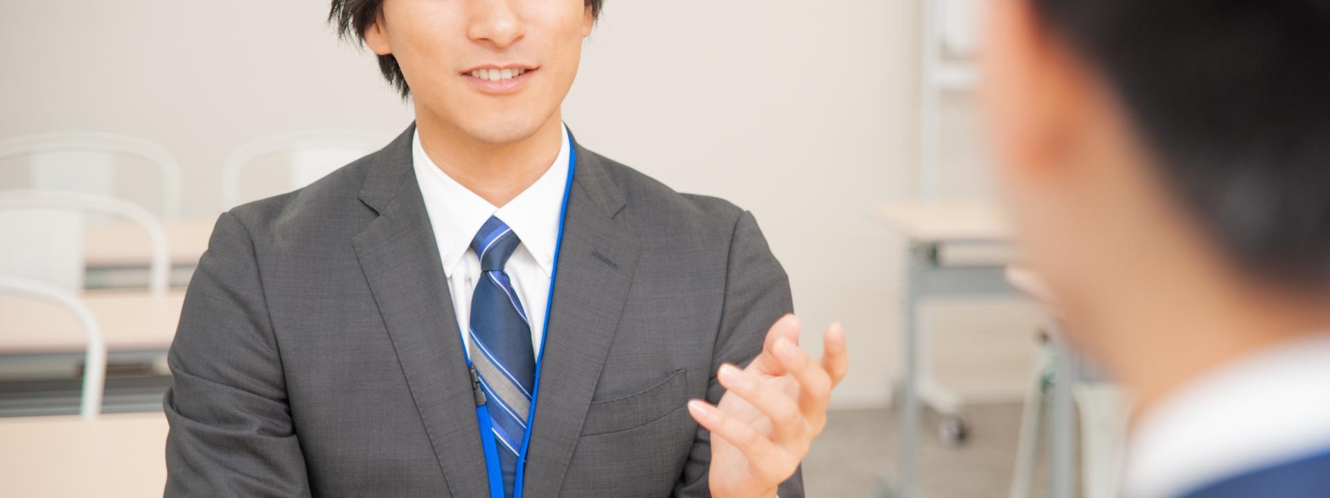 スーツ姿の男性が商談中に話す場面