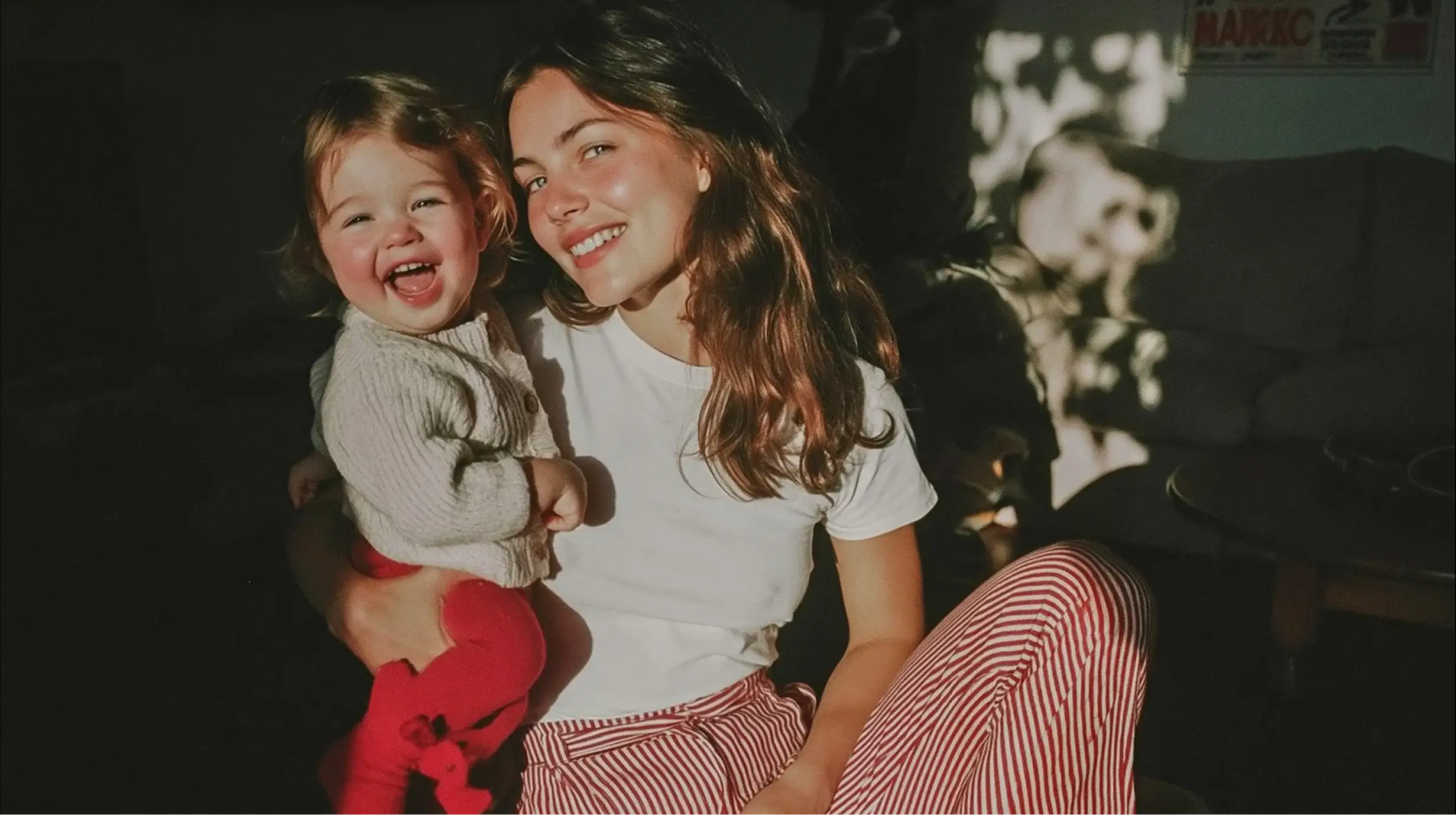 A mother holding her laughing toddler.