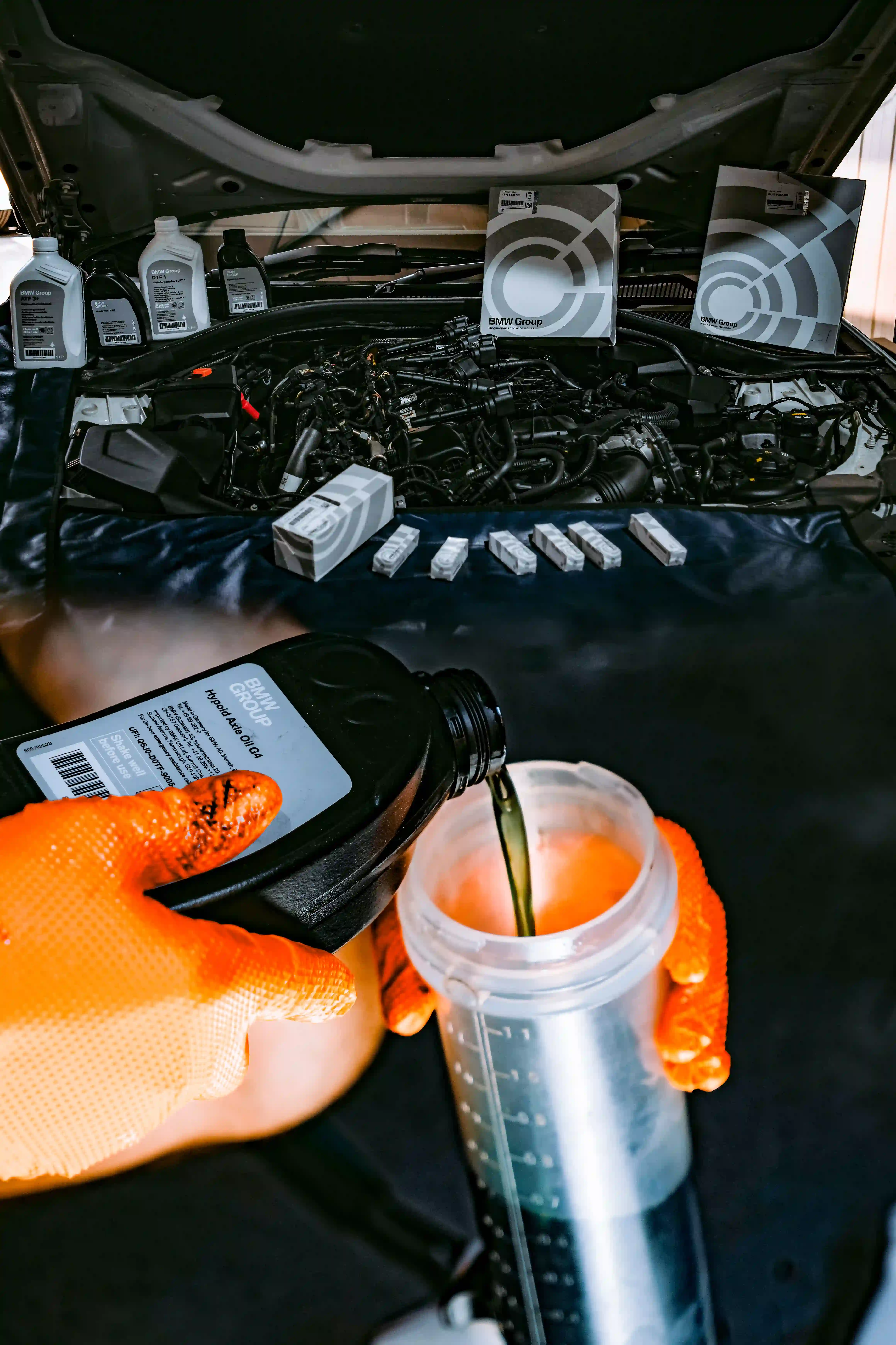  Mechanic pouring fluid into car.