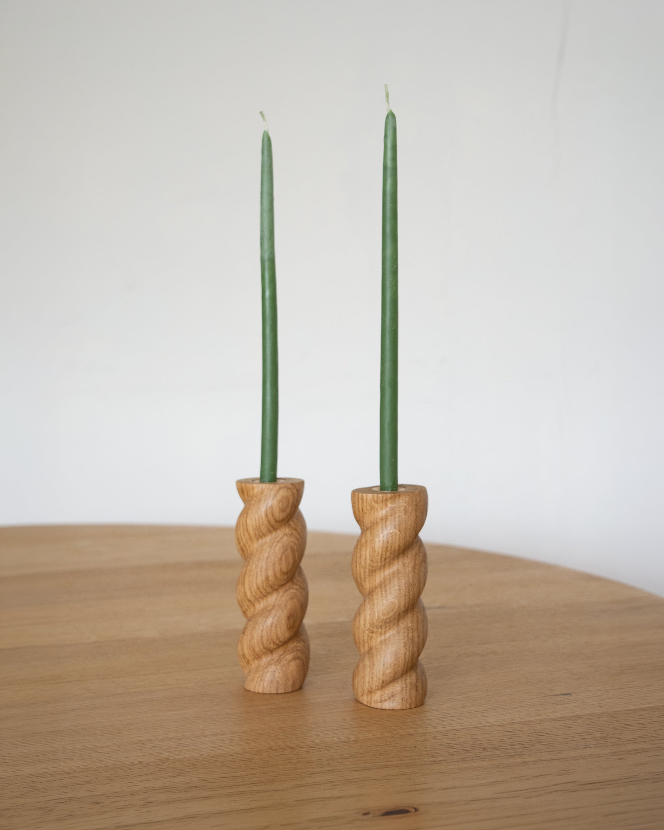 Twisted 99 Candlestick Holder Pair by Wilkinson & Rivera on oak table afar