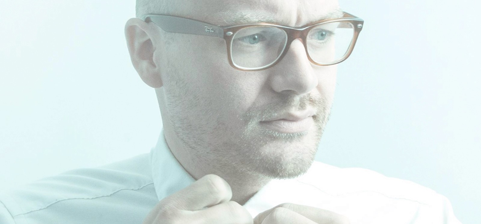 Person with yellow rain jacket looking over at mountains.