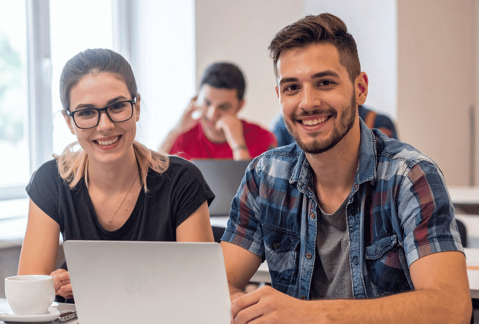 Two people smiling in front of computer