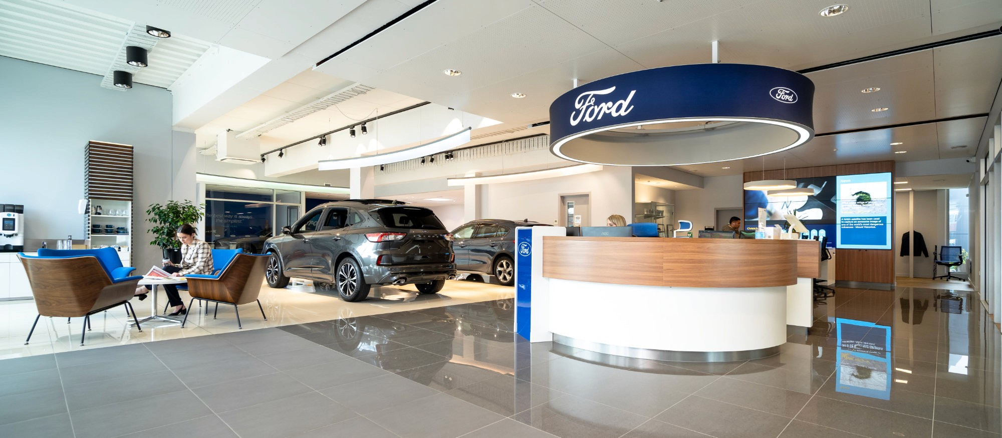 Greenhous Ford dealership fit-out with reception desk, display vehicles and branded showroom signage