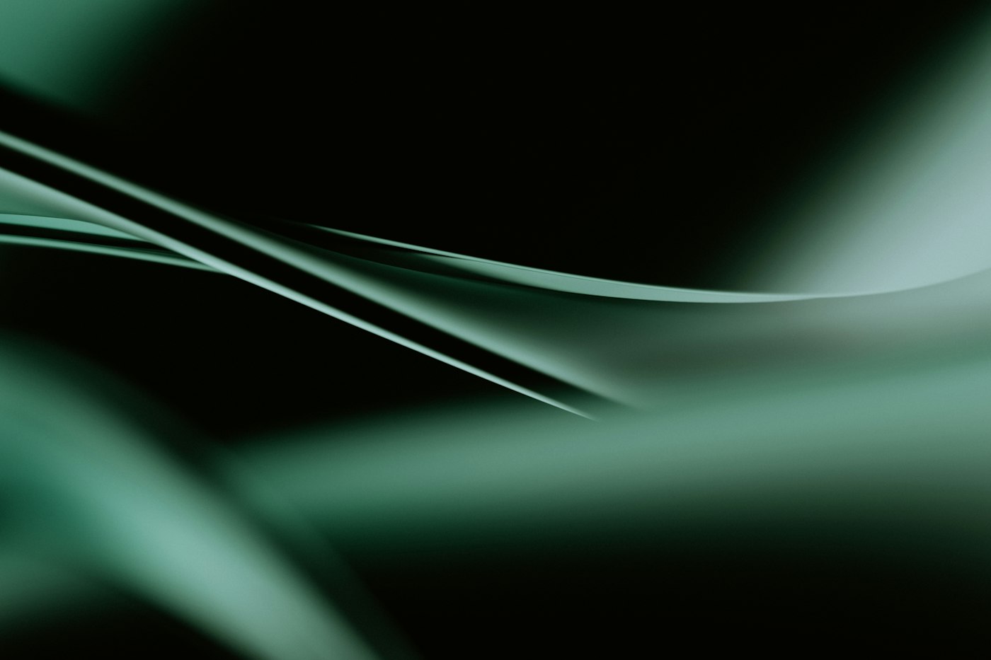 Long emerald light streaks sweeping across a black background