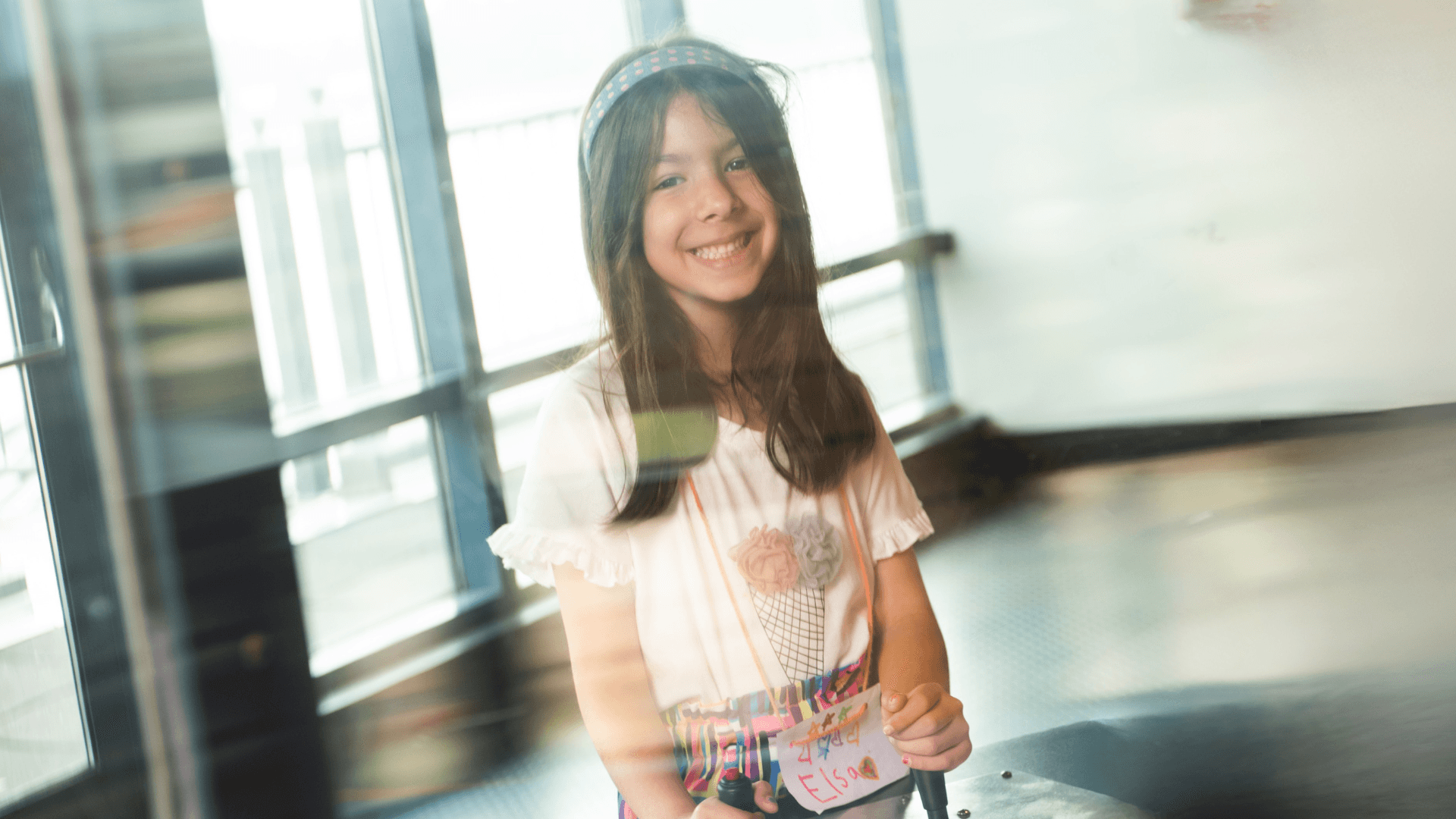 A young girl smiles as she plays with an interactive solar exhibit.