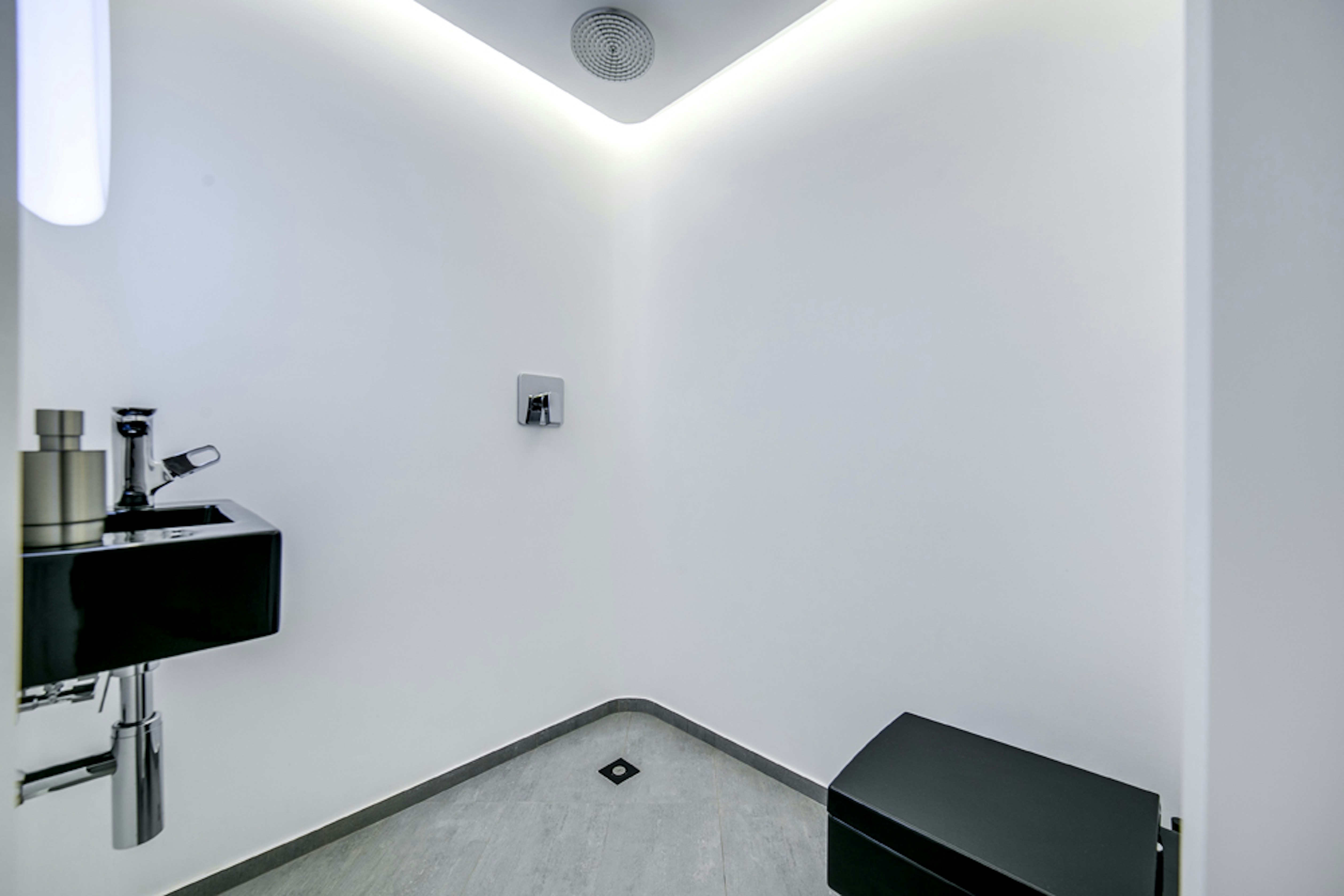 a white bathroom with a black sink and mirror