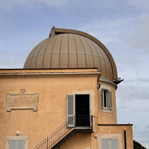 擁有一個大型圓頂形屋頂、兩個封閉的窗戶、一扇開放的門配上金屬樓梯,以及牆上的一塊匾牌。