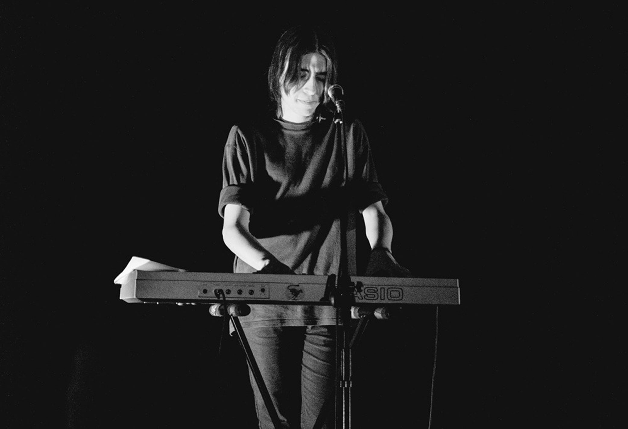 Live performance photography of Primeira Dama featuring minimalist black and white stage lighting.