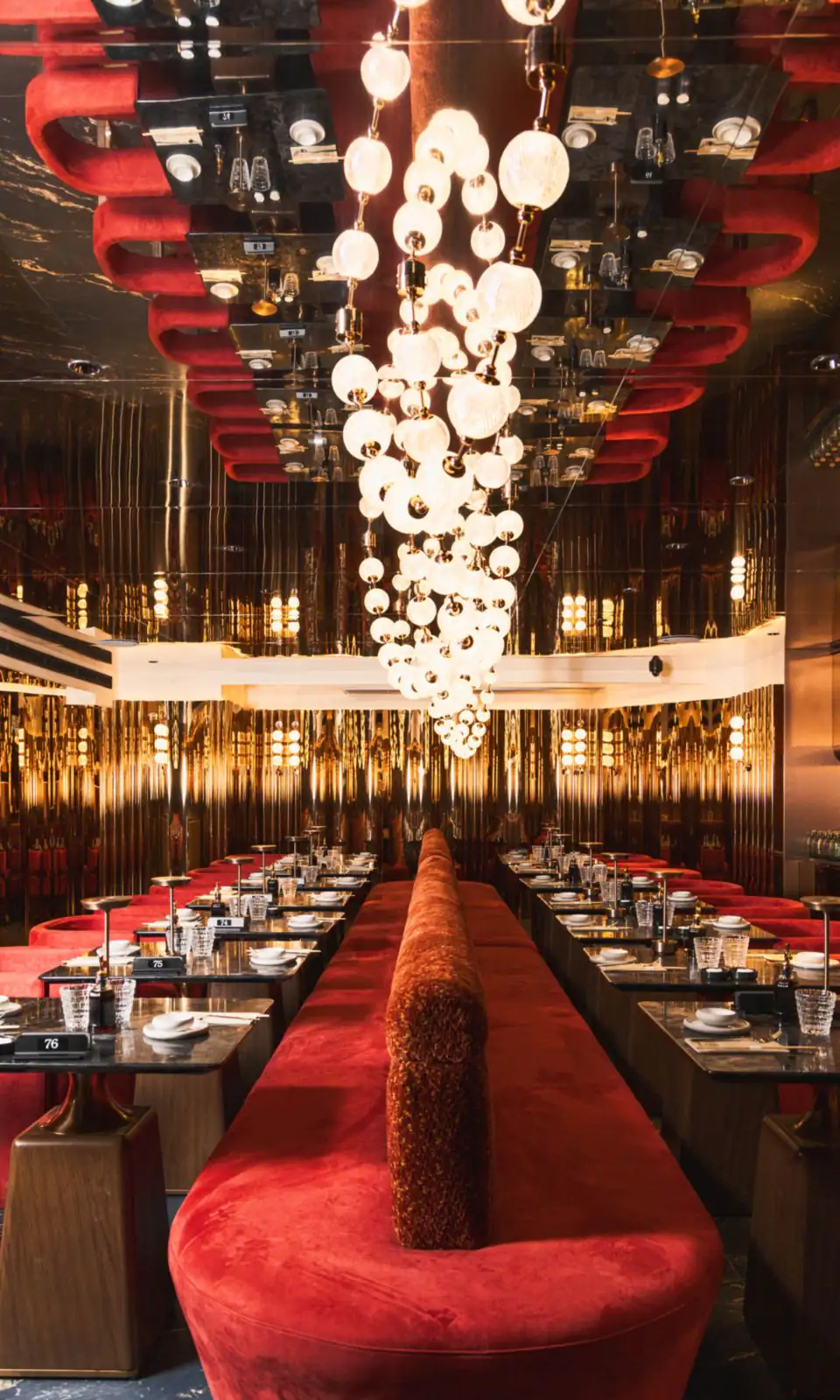 Sushi Club Porte Maillot 大厅:发光球体瀑布吊灯、红丝绒长椅与铜色镜面