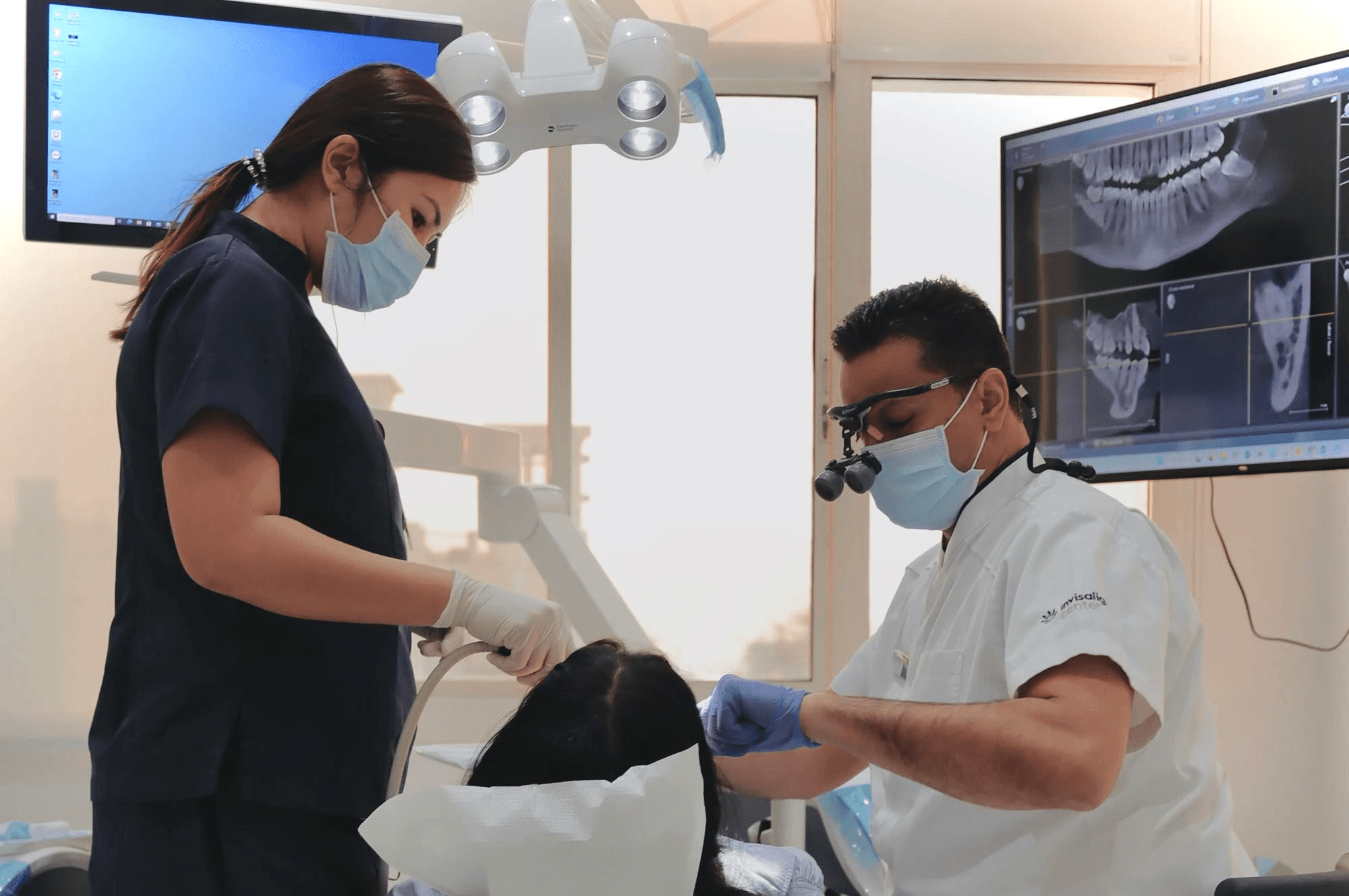 A dentist and his assistant performing a regular check up to see what type of Hollywood smile is perfect for the patient by Invisalign Center