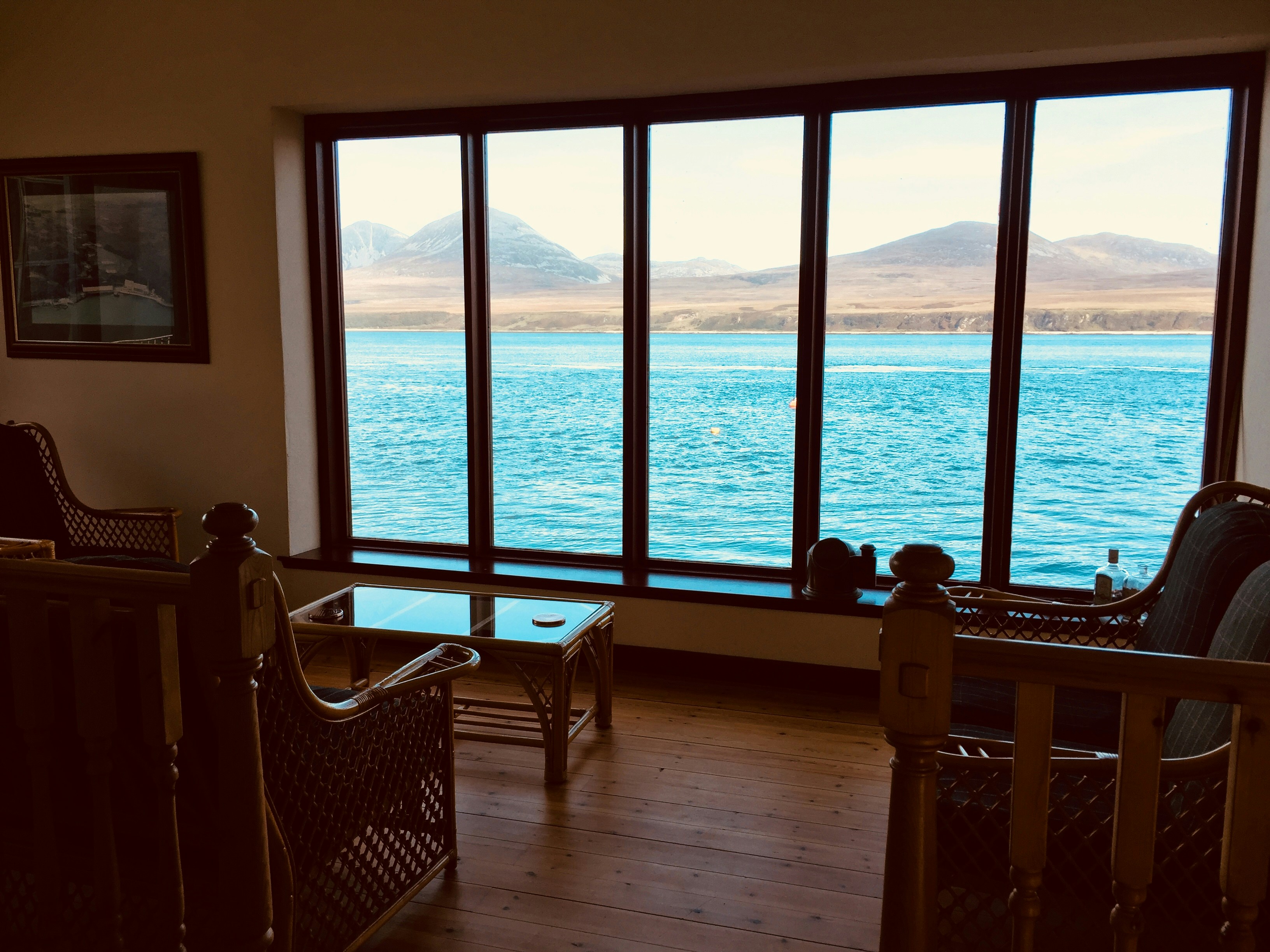 A living room with big windows facing open water