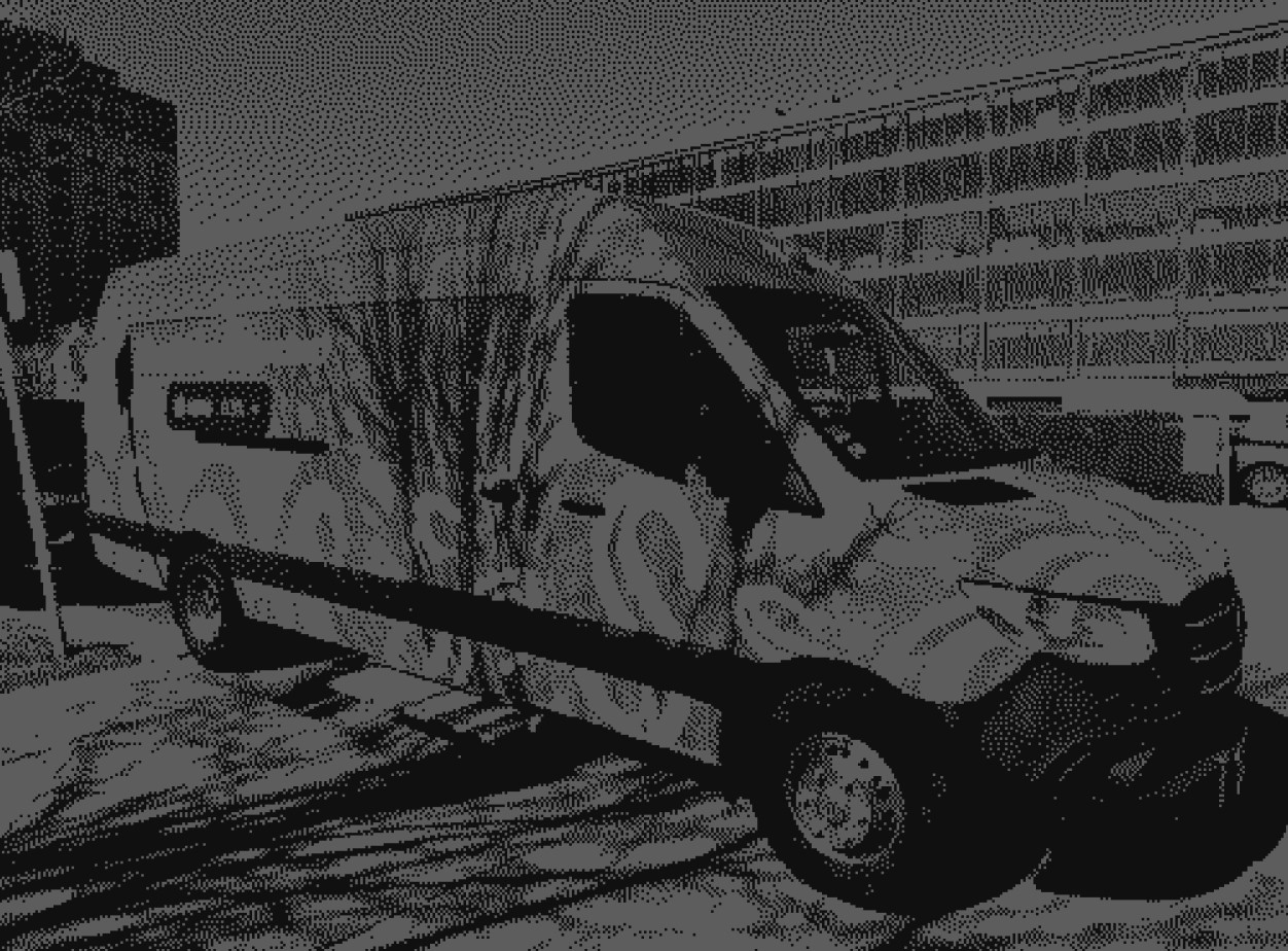 Modern red brick apartment or office building viewed from below against a blue sky, showcasing its geometric architecture with evenly spaced windows and balconies.