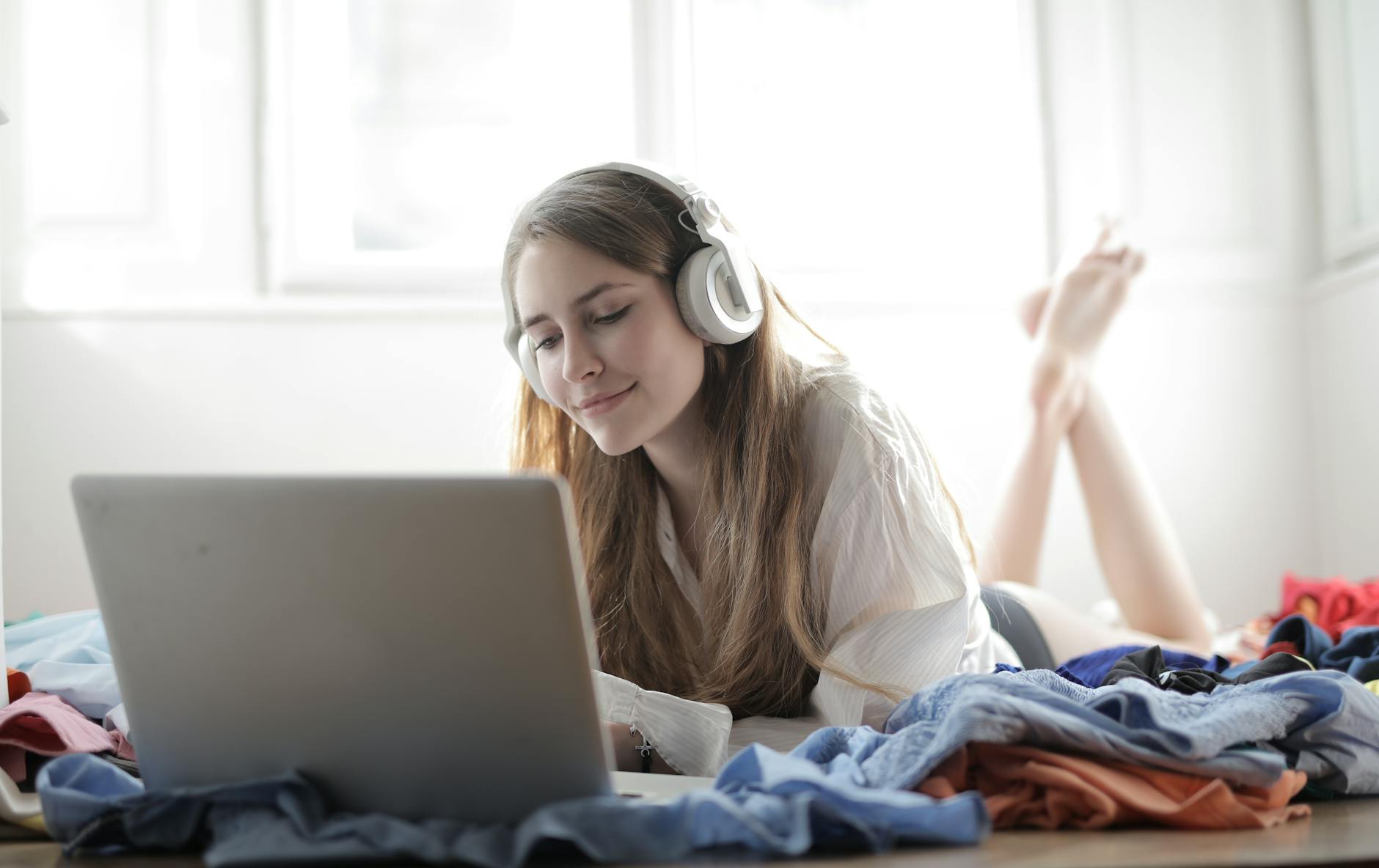 A female educator wearing headphones while participating in a virtual professional development webinar on her tablet.