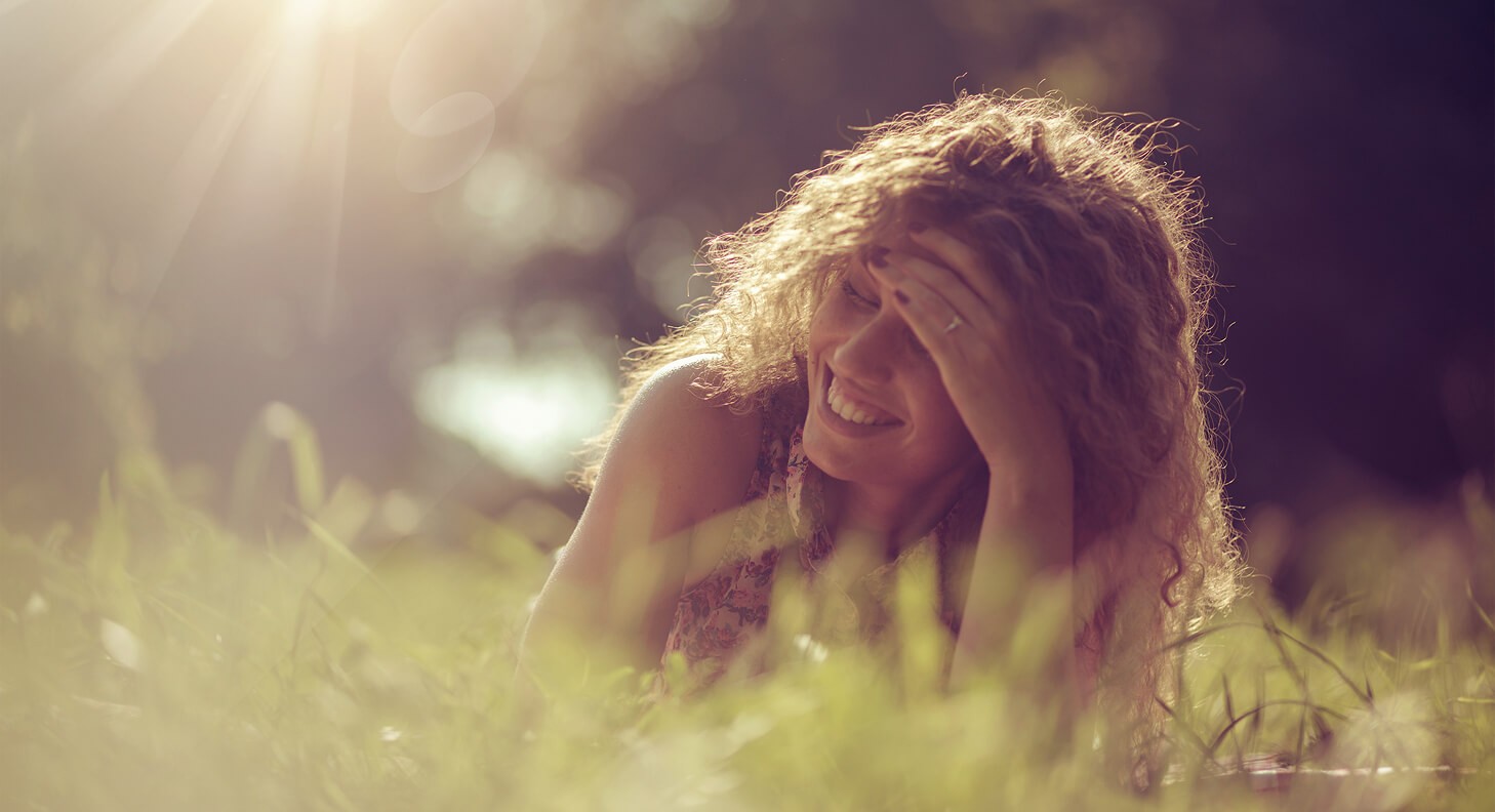 woman smiling in a field in the sun