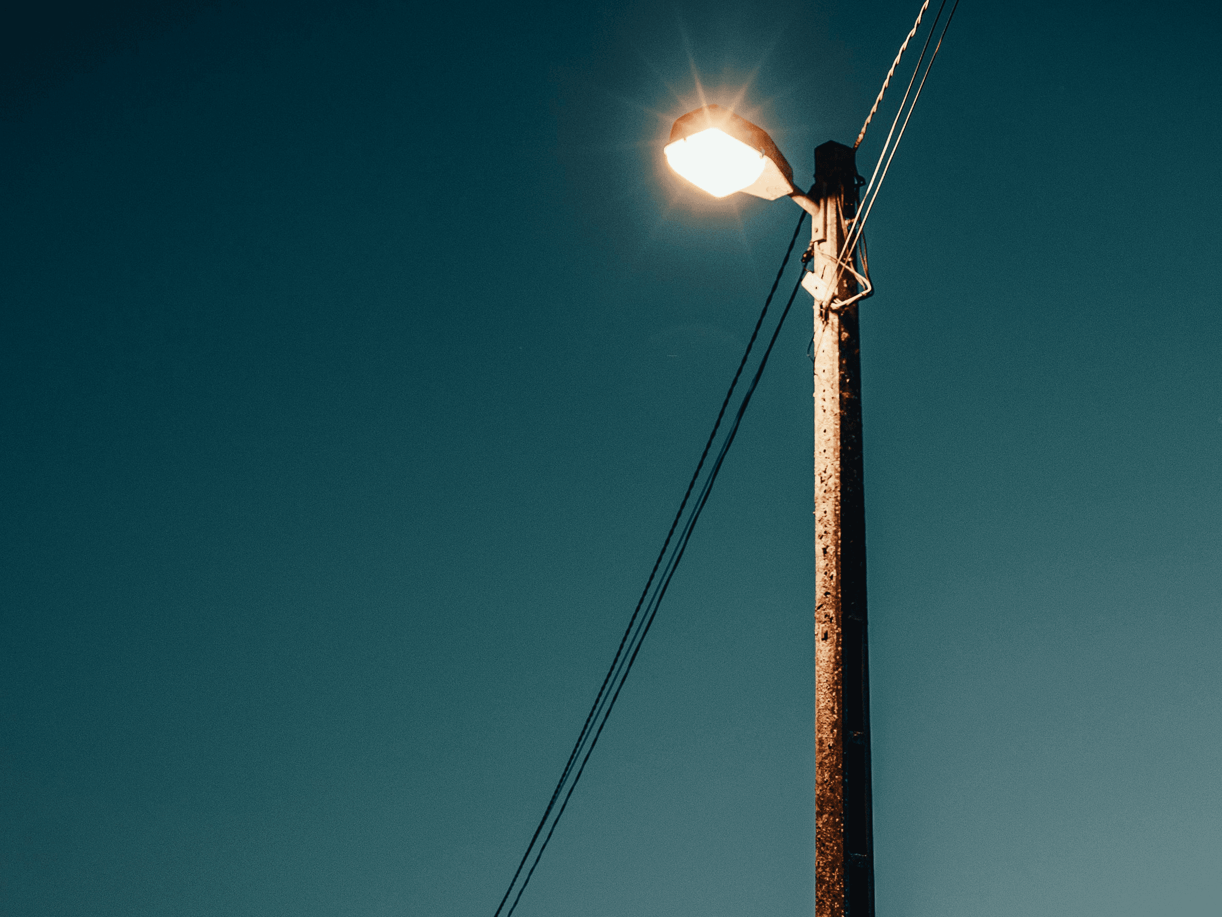 a street light sitting on the side of a road
