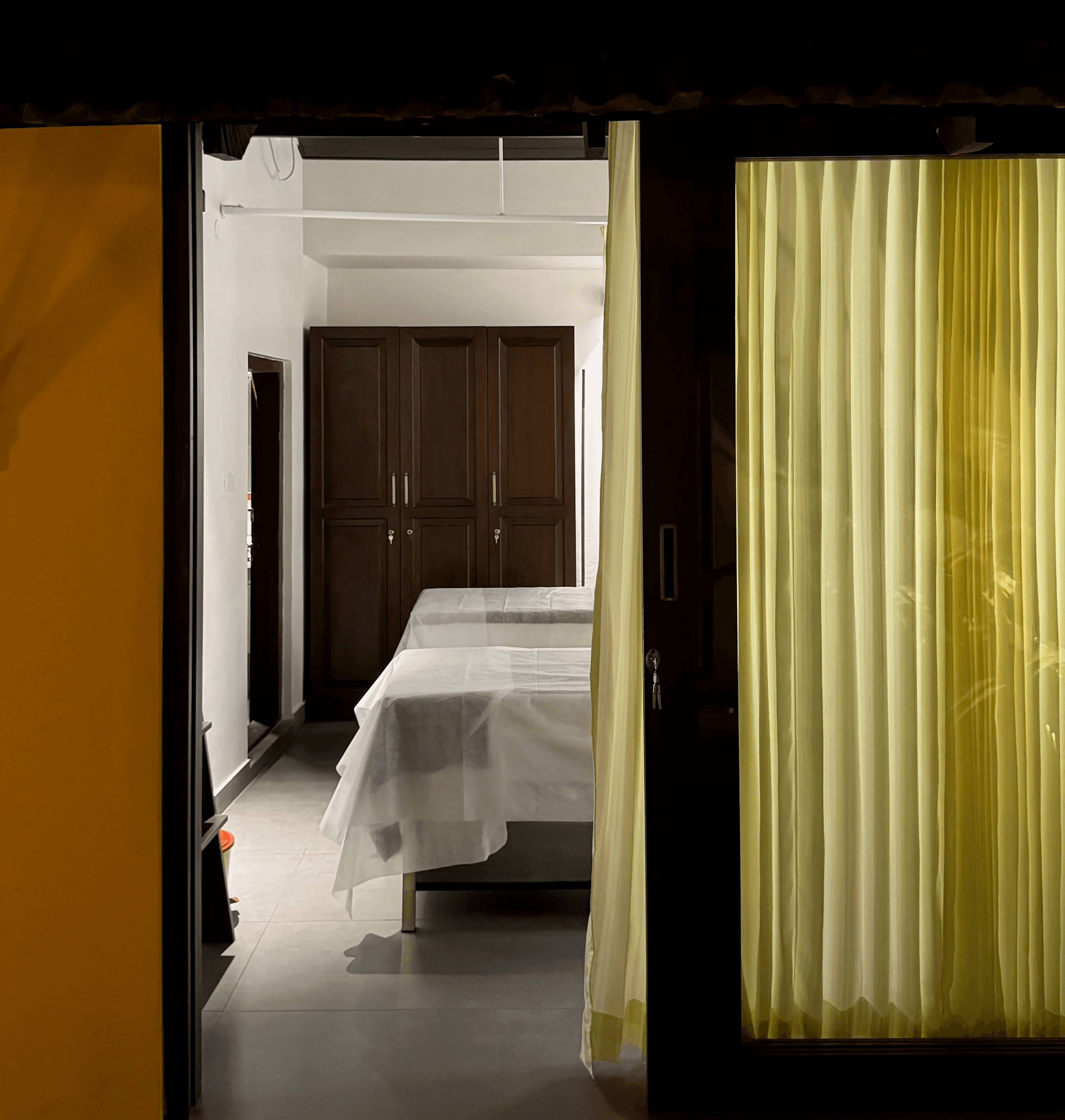 A serene spa setting with two lounge chairs beside a warm, reflective pool and soft, natural lighting.