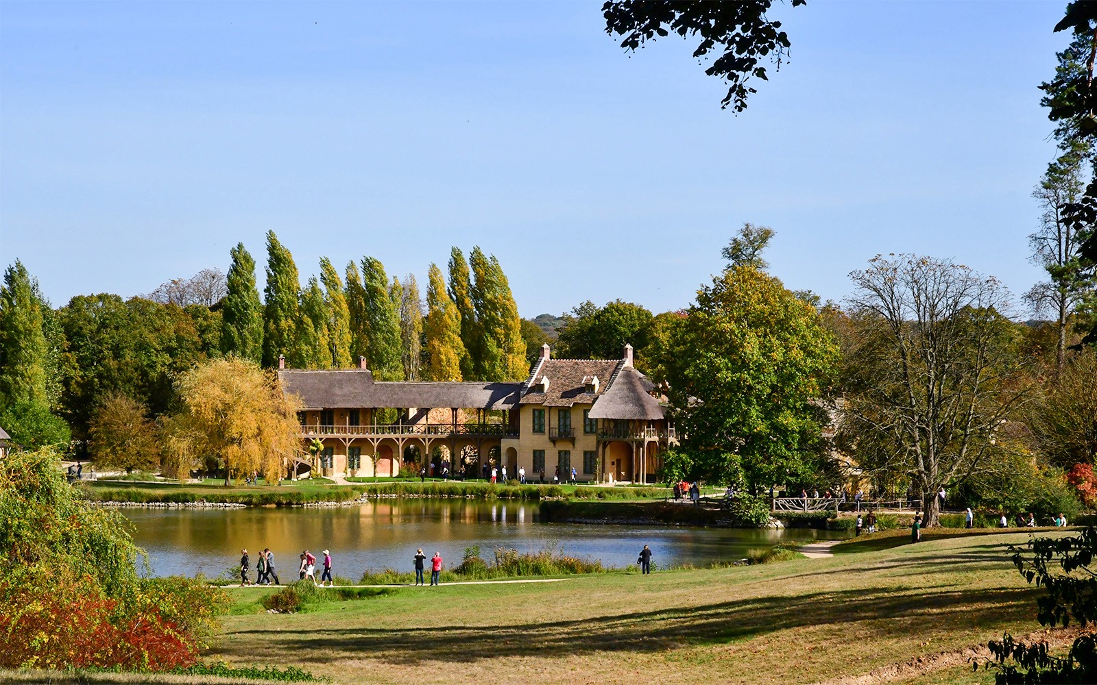 Desa Ratu di Versailles dengan bangunan-bangunan pedesaan di tepi kolam yang tenang.