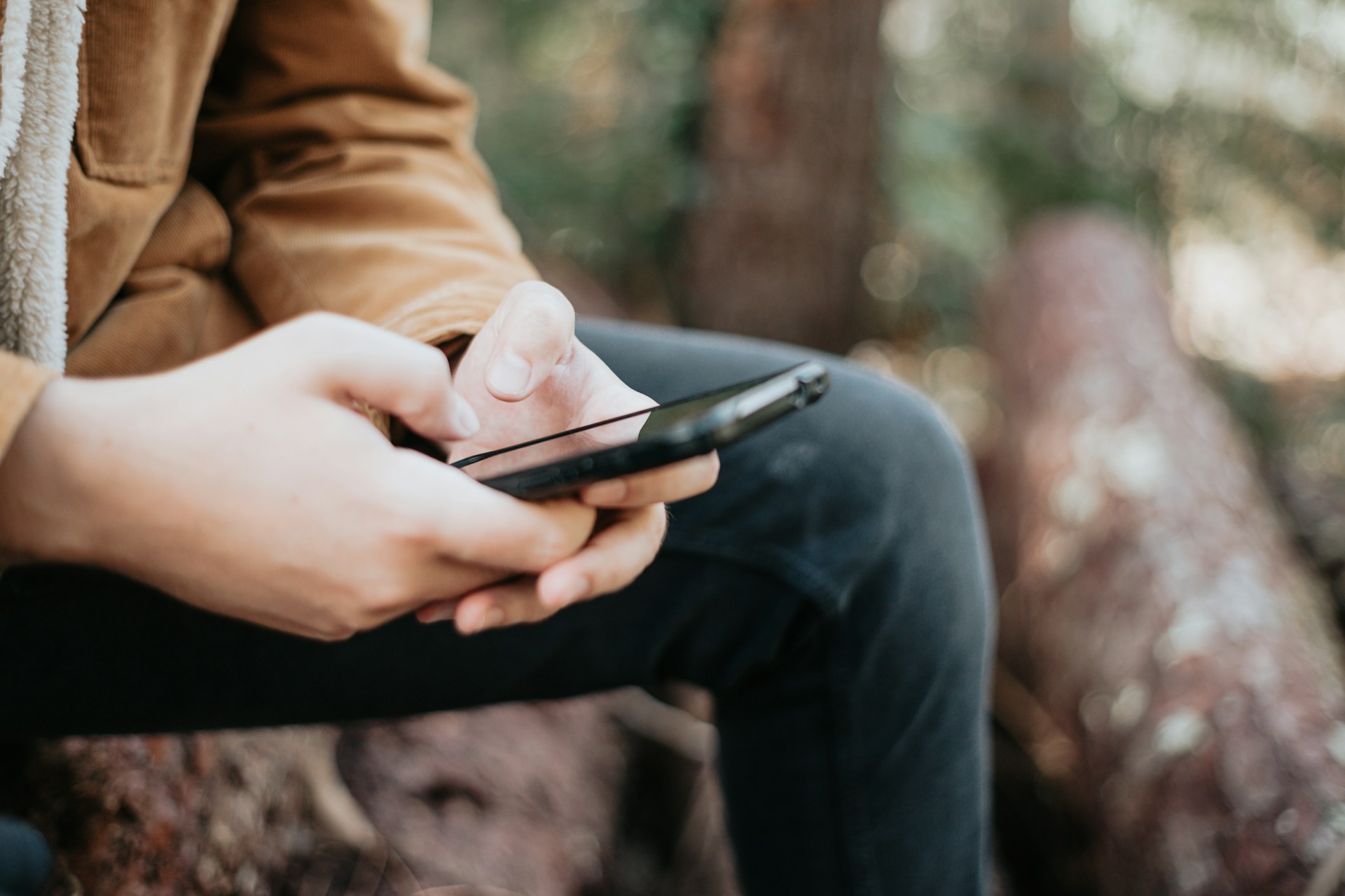 A person sitting while holding a phone