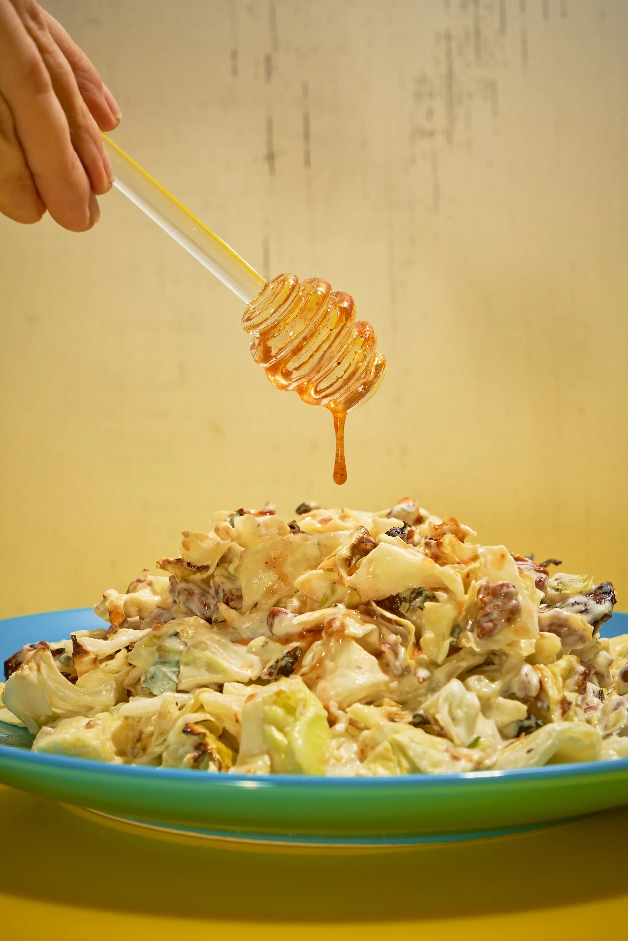 Charred cabbage with whipped feta as hot honey drips from a glass honey wand
