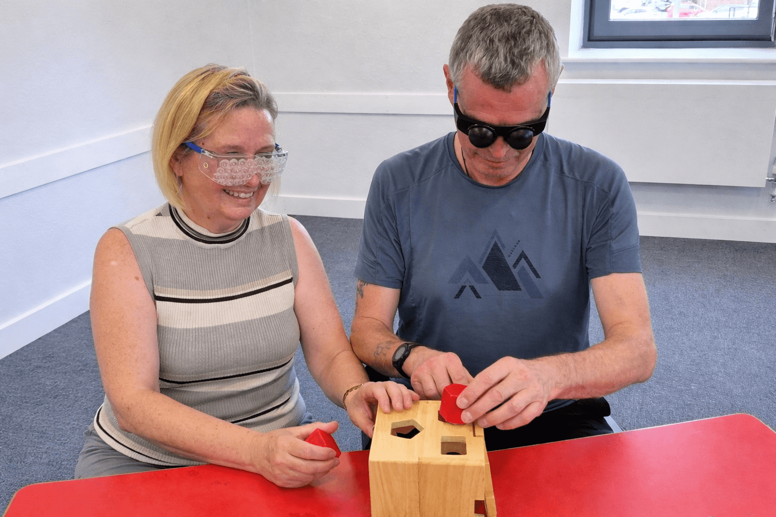 Two support workers doing deafblind training with goggles