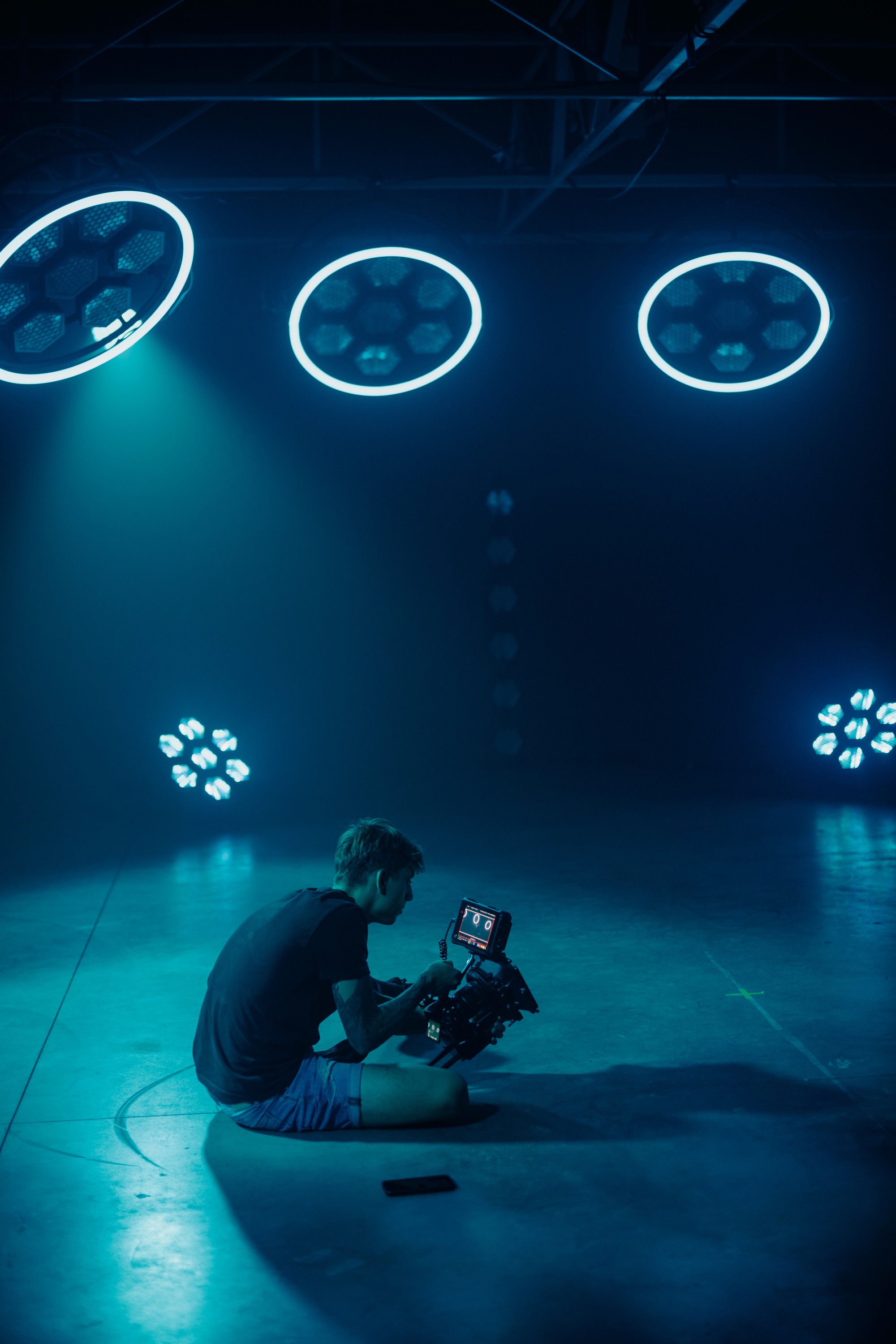 Close-up of a yellow tennis ball sitting on a green court, positioned near the white center line.