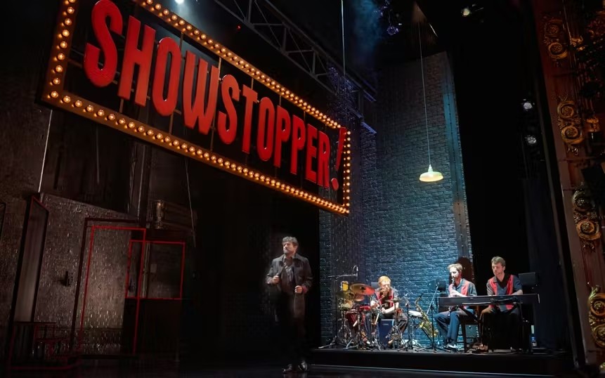 Showstopper! The Improvised Musical cast and band performing on a West End stage.