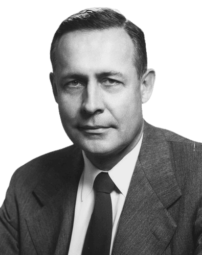 A black-and-white portrait of a man with a serious, confident expression, wearing a suit, white shirt, and dark tie. His neat hair and formal attire convey professionalism and authority, suggesting he is a prominent business or political figure from the mid-20th century.