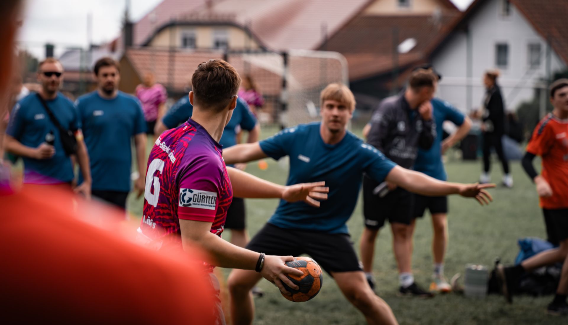 Young players fight for the ball during a street handball game