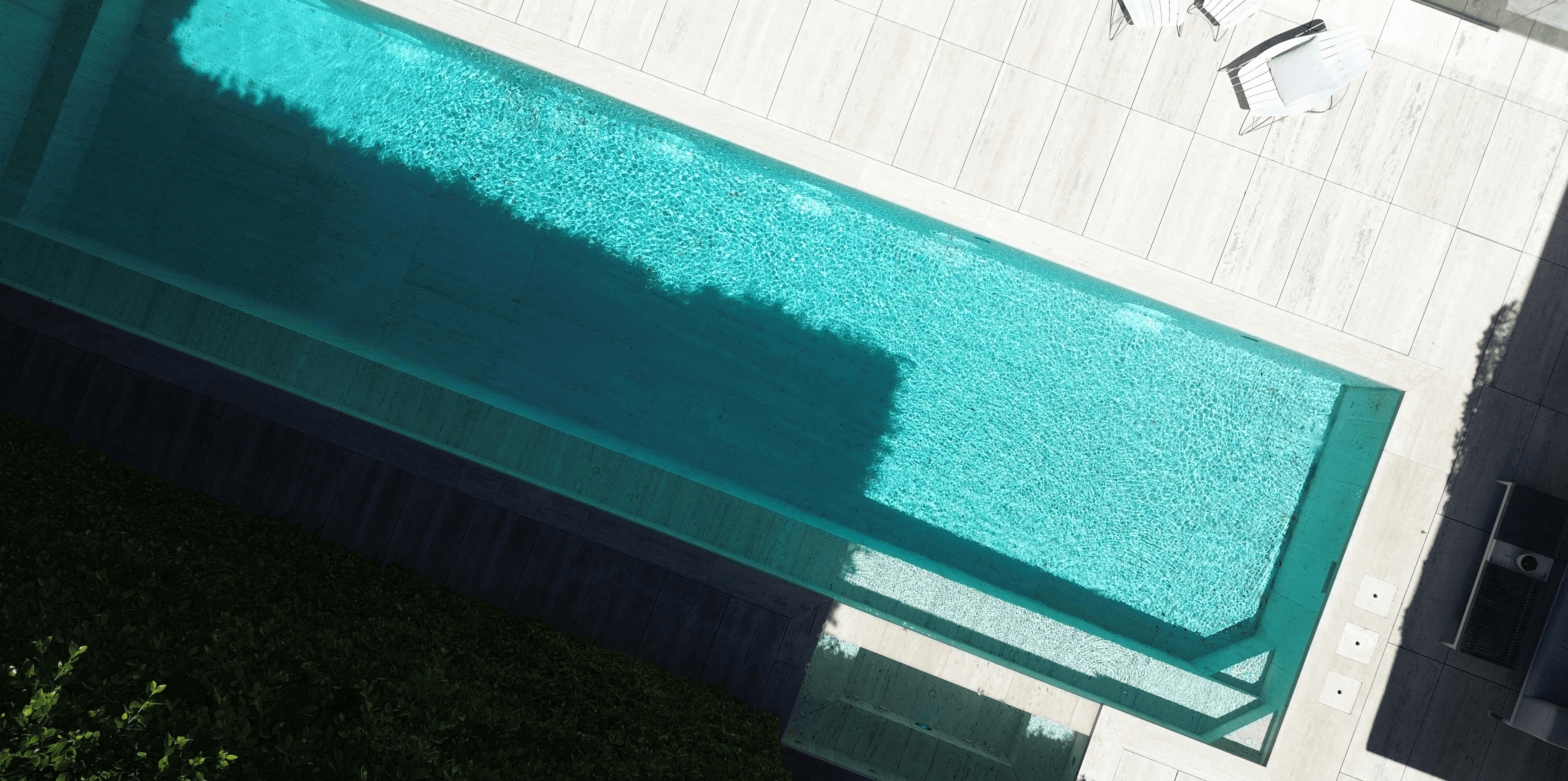 An aerial view of a modern rectangular swimming pool.