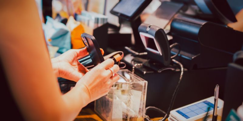 Seorang wanita membuat pembayaran tanpa tunai di kaunter