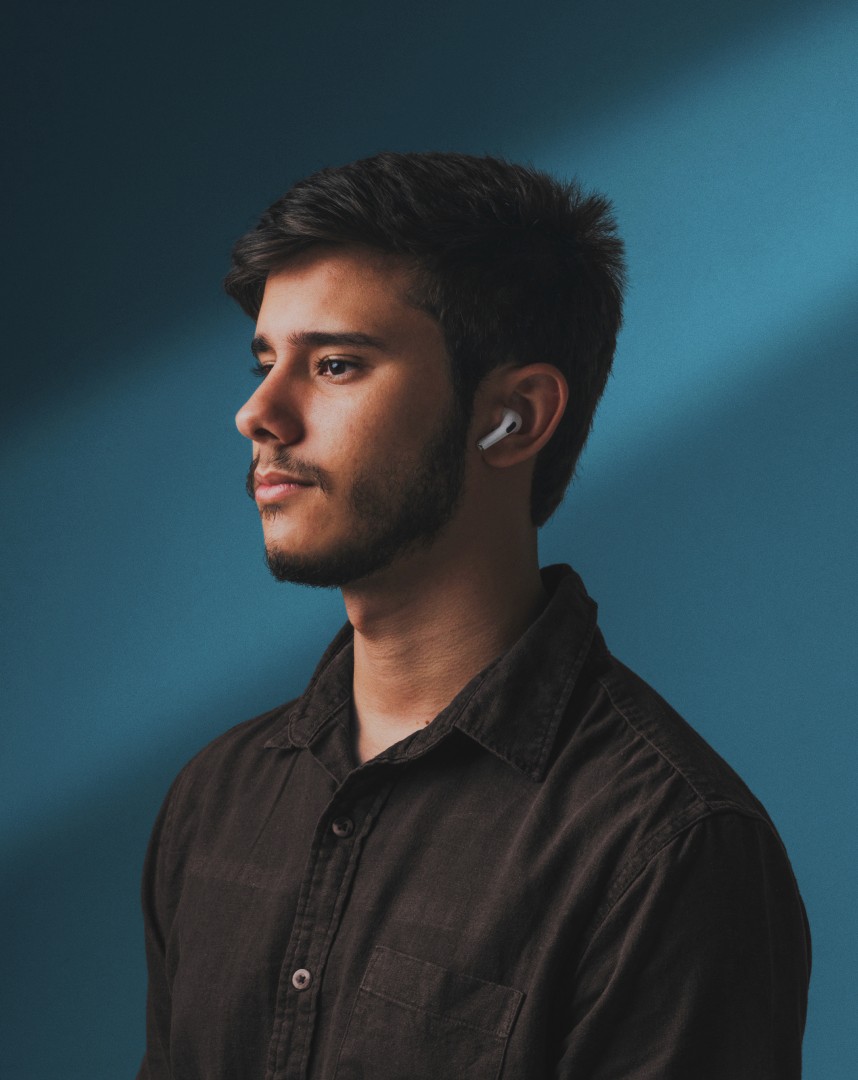 Modern glass and steel building with warm wooden ceilings, surrounded by lush greenery, blending contemporary architecture with nature.