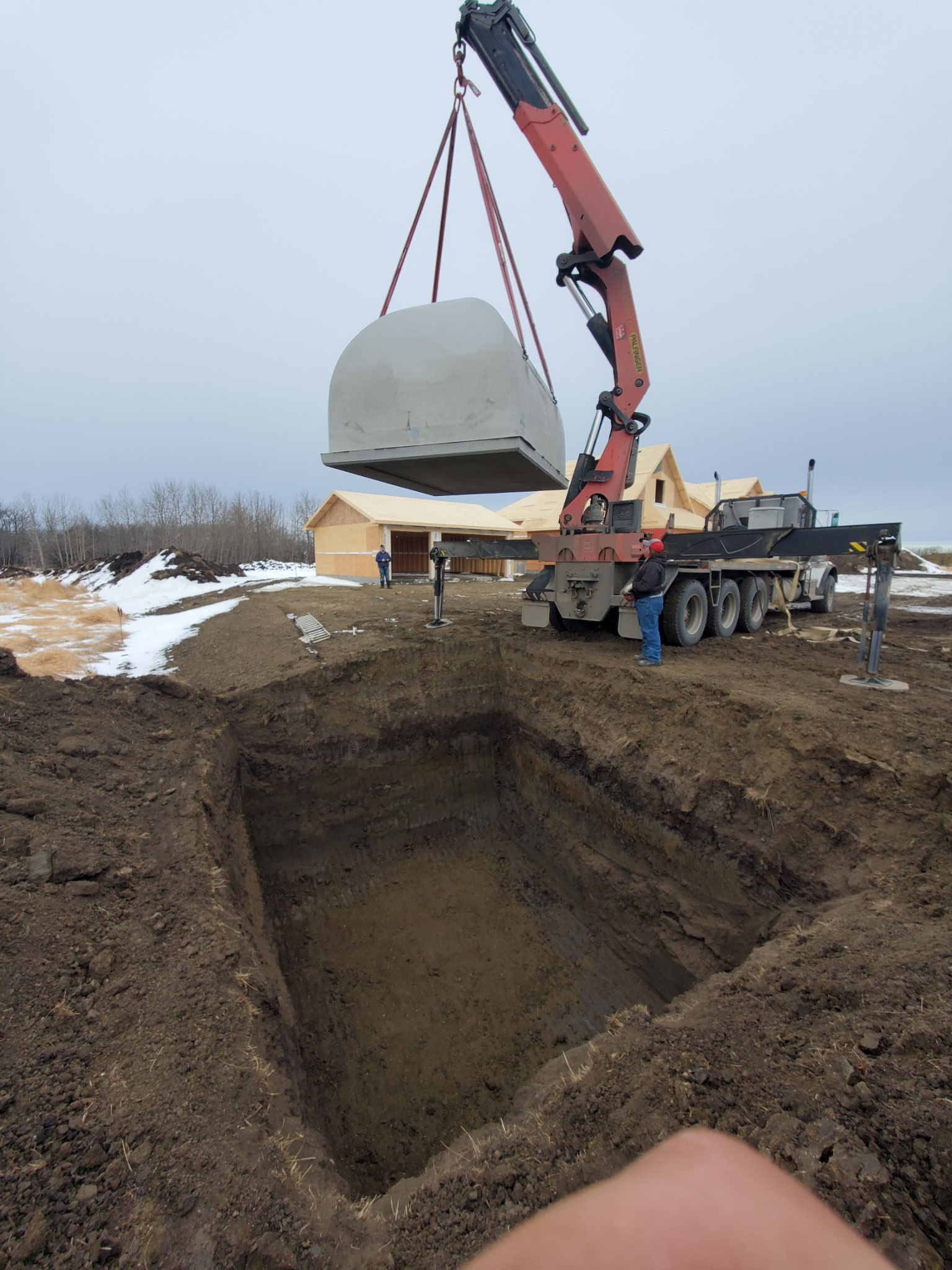 A septic tank being lowered into a hole