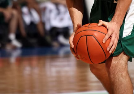 Basketballspieler hält einen Ball – Sportförderung des SSV Lokomotive Bernau durch die DAG Unternehmensgruppe.